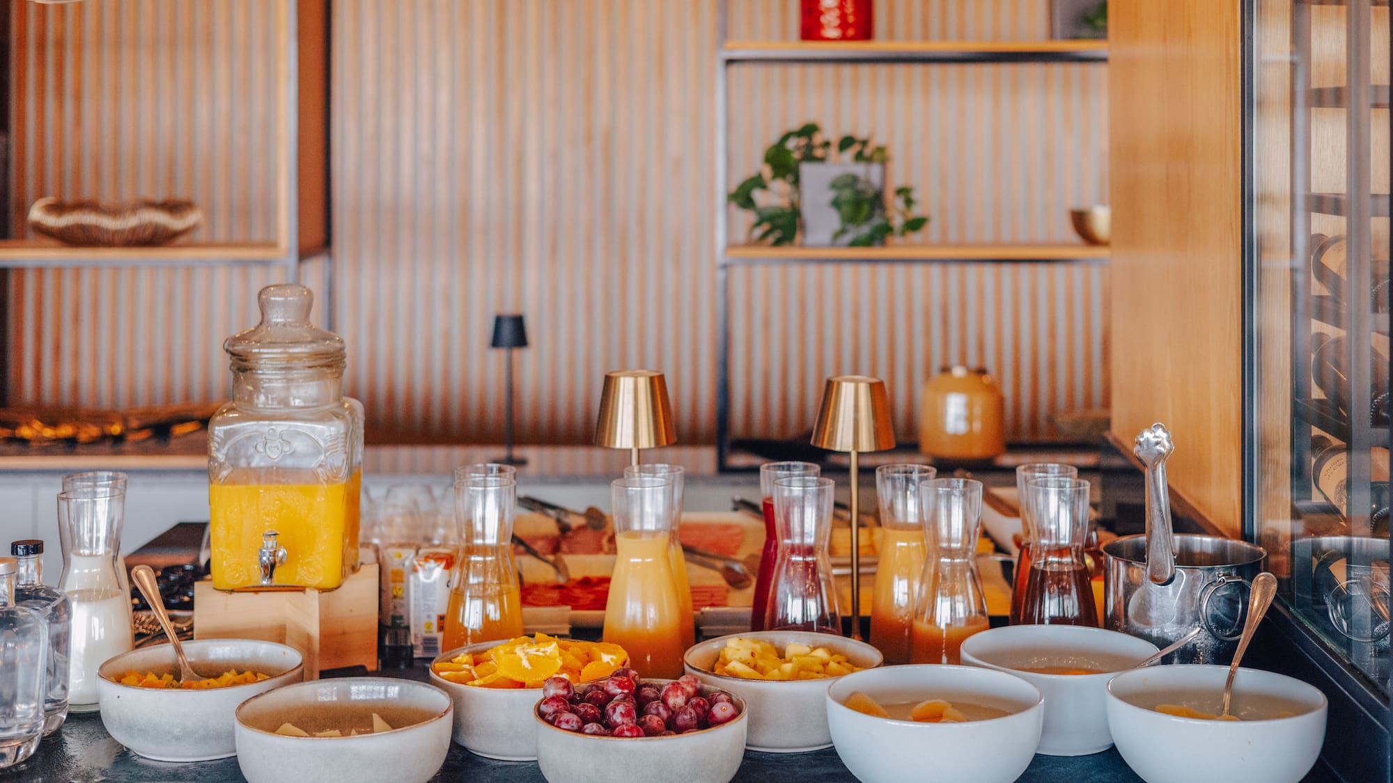Hotel breakfast buffet with fresh juices, fruit bowls, and elegant decor.
