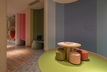 a room with a table and colorful chairs
