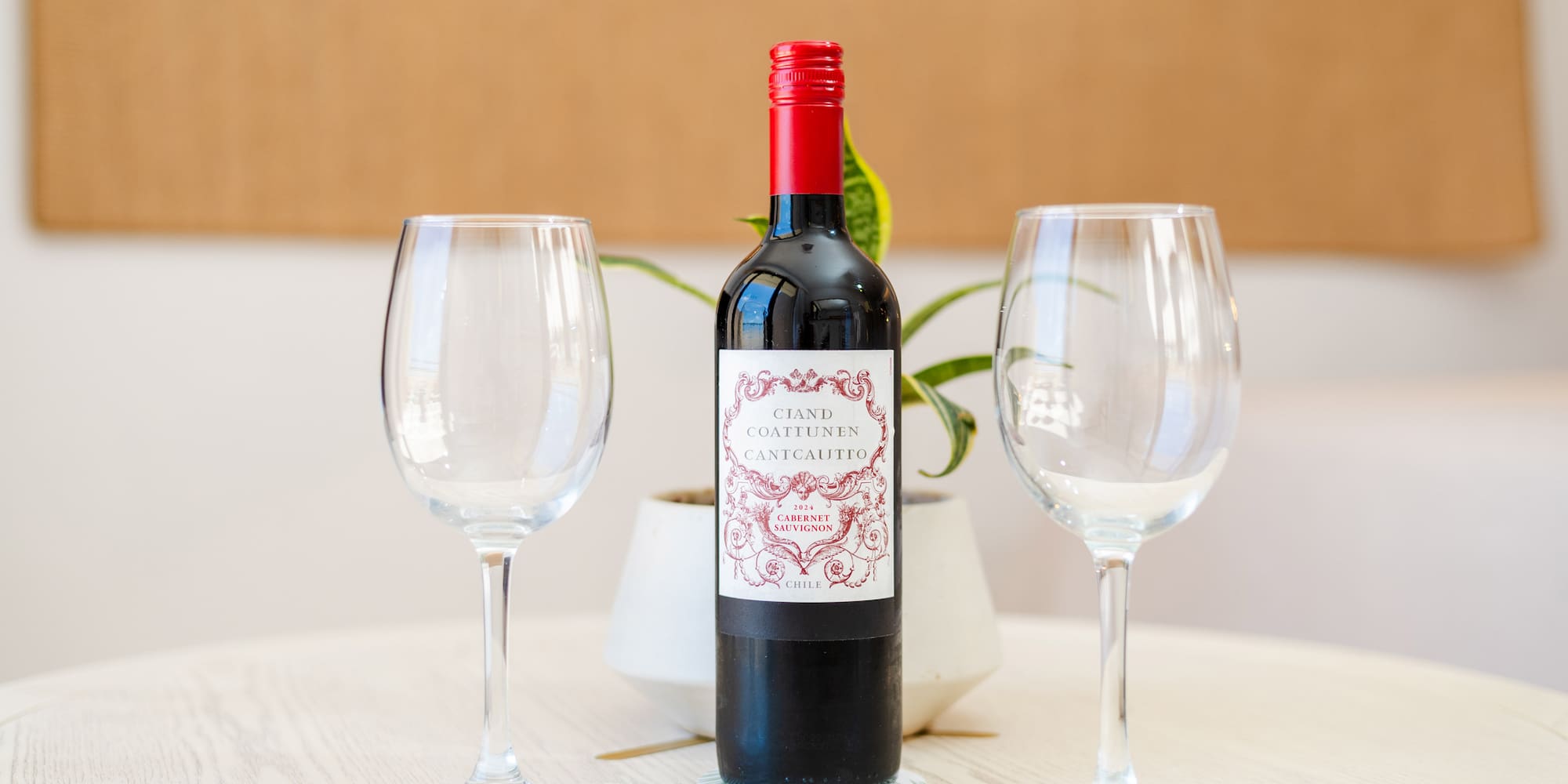 a bottle of wine and two empty wine glasses