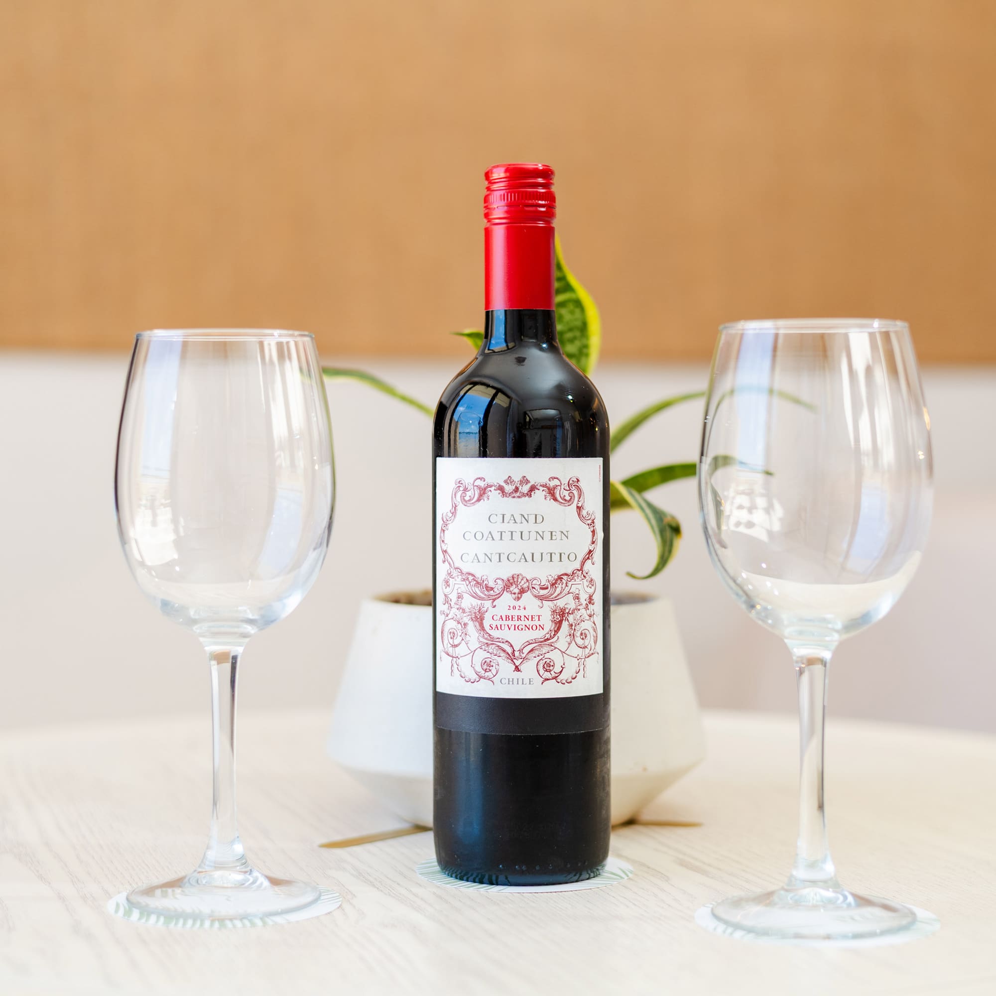 a bottle of wine and two empty wine glasses