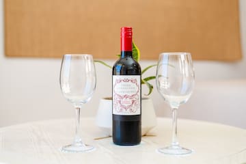 a bottle of wine and two empty wine glasses