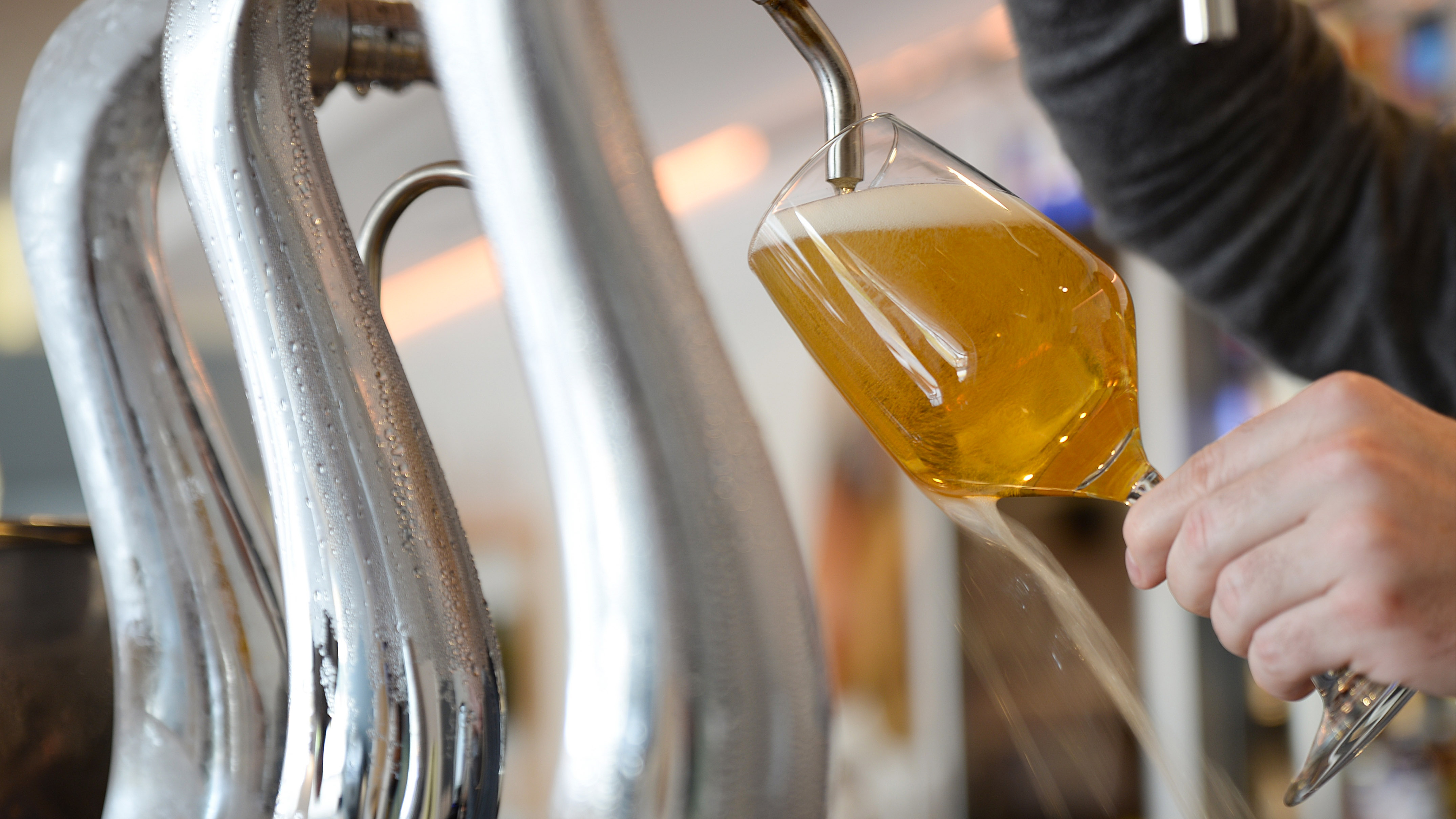 a person pouring a glass of beer