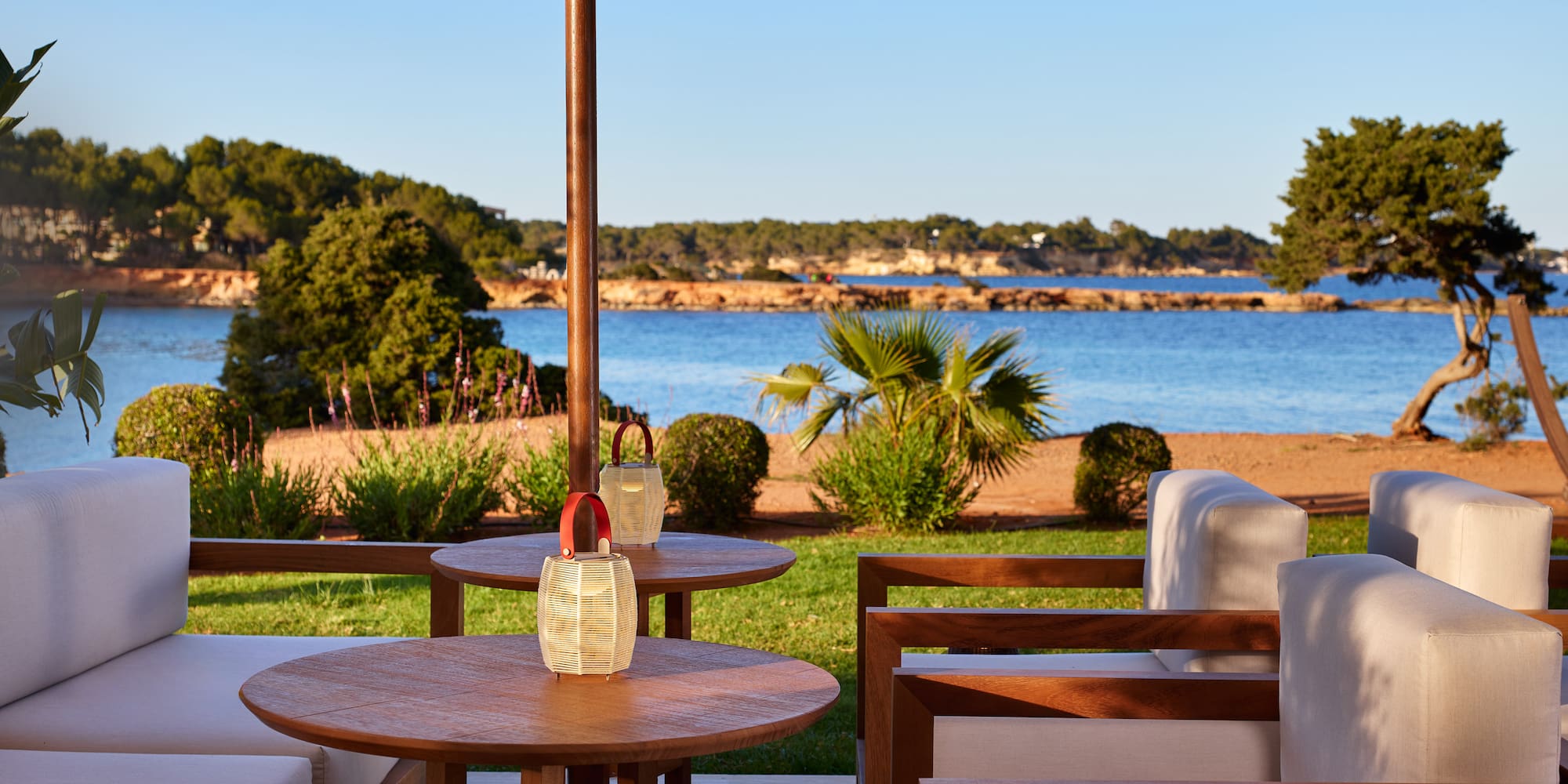 a table and chairs with a large umbrella on a beach