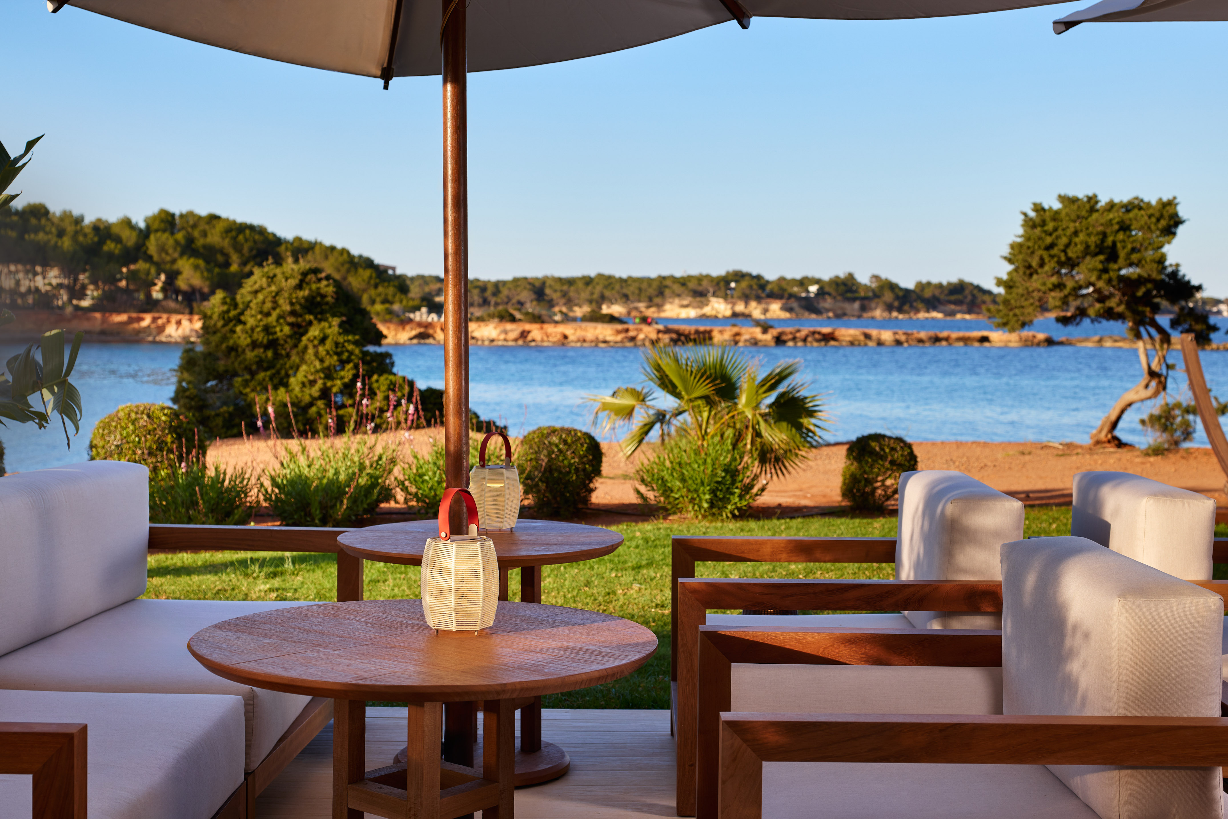 a table and chairs with a large umbrella on a beach