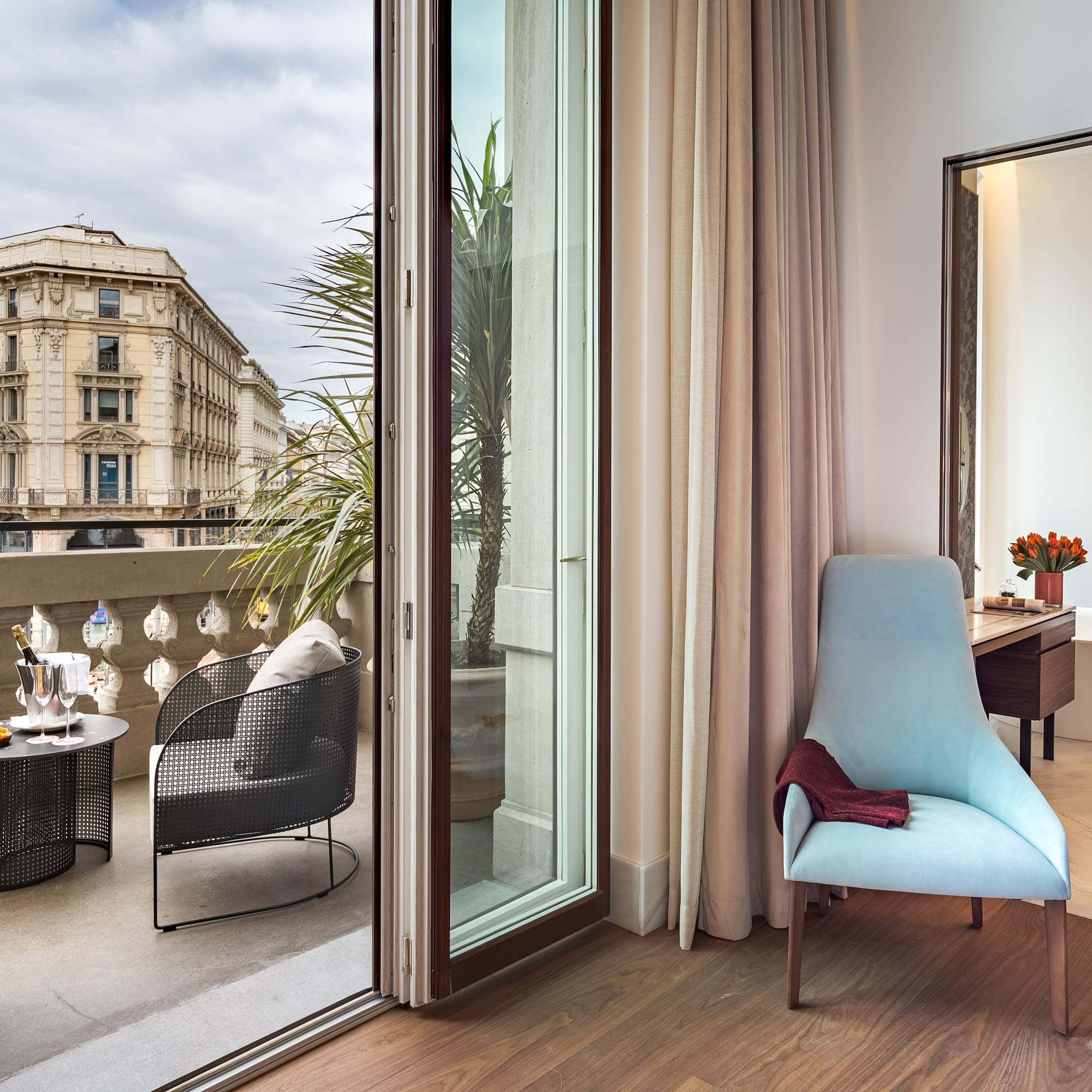 a room with a glass door and a chair and a table