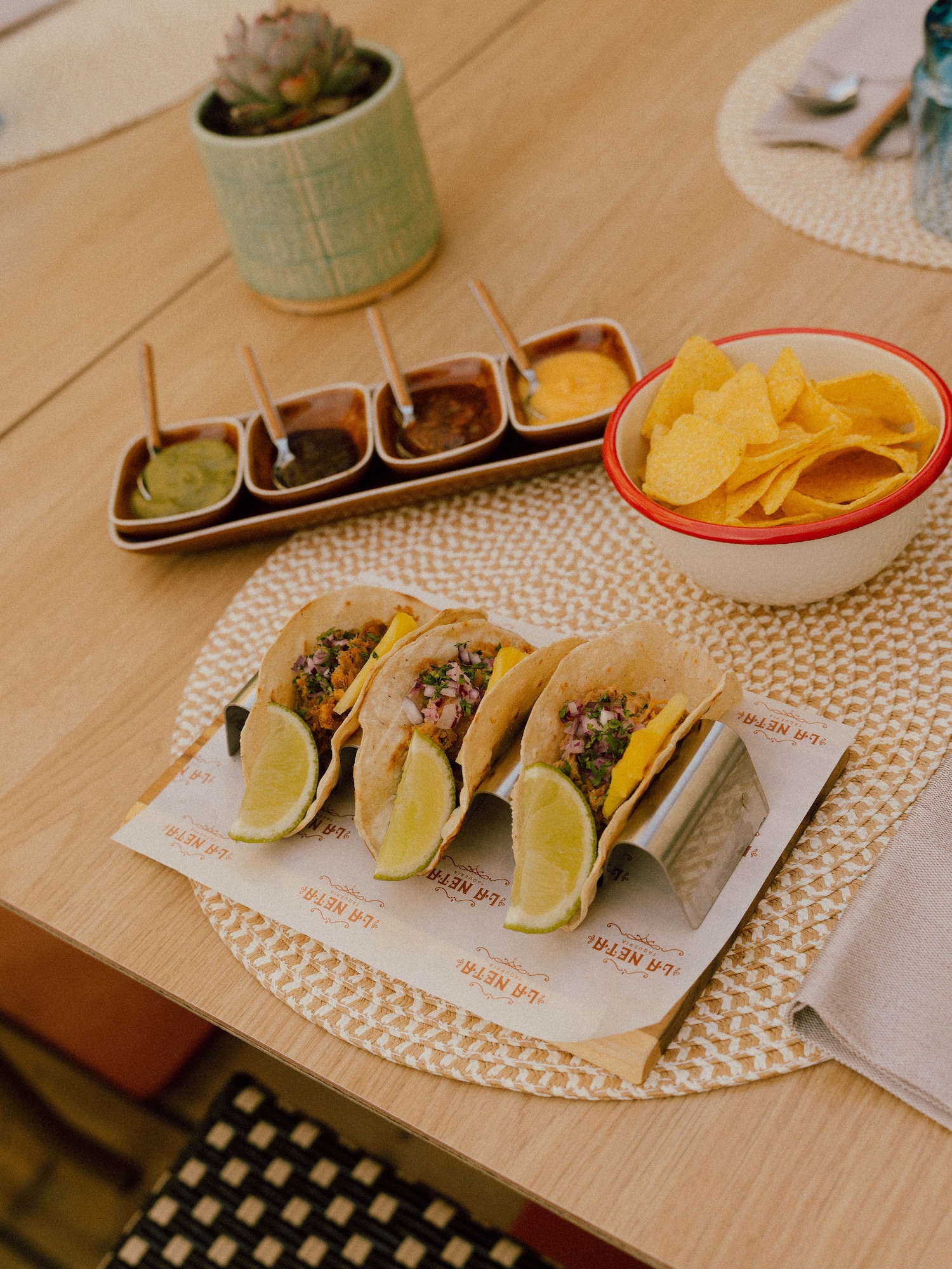 Delicious tacos with lime, varied salsas, and tortilla chips at a taqueria.