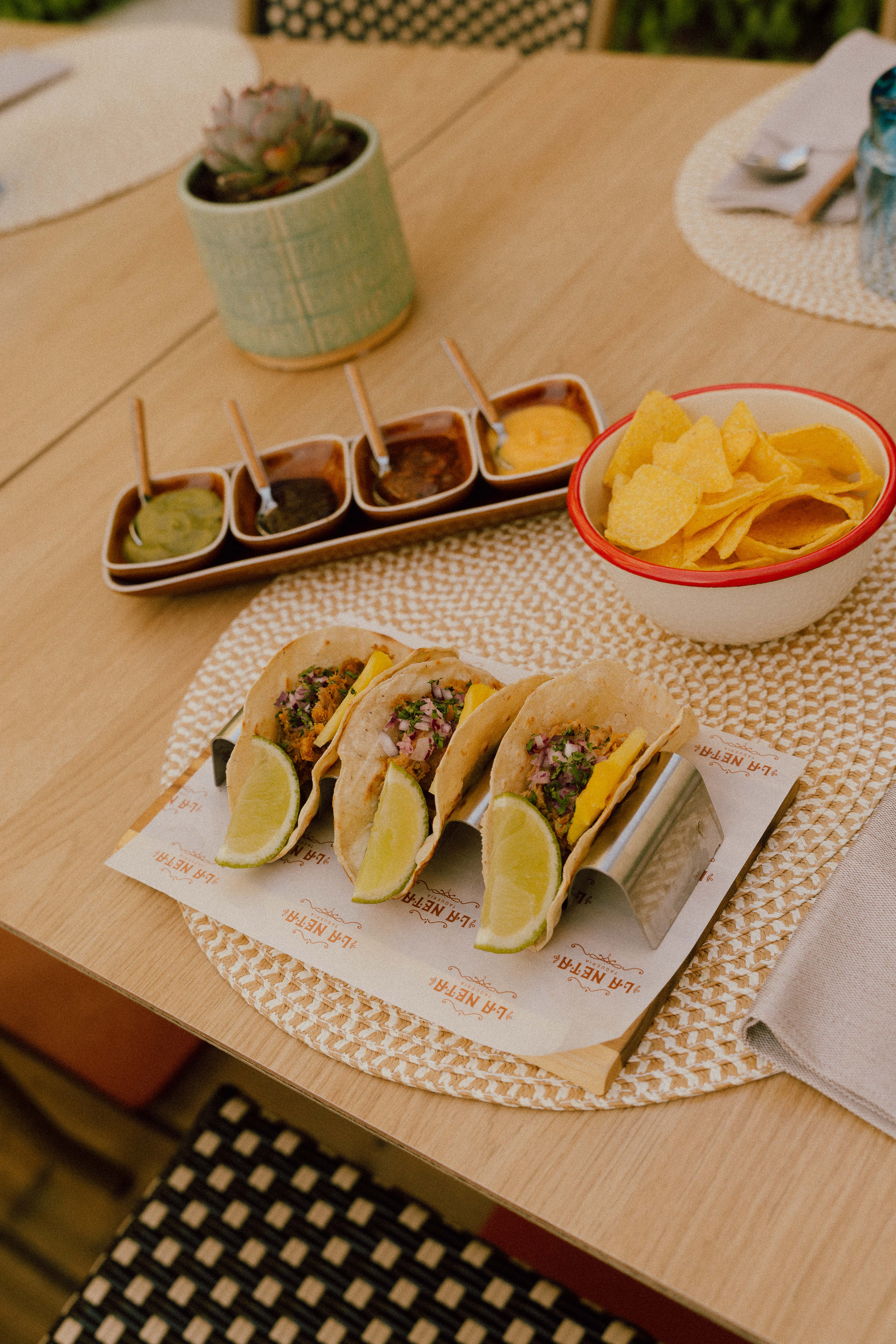 Delicious tacos with lime, varied salsas, and tortilla chips at a taqueria.