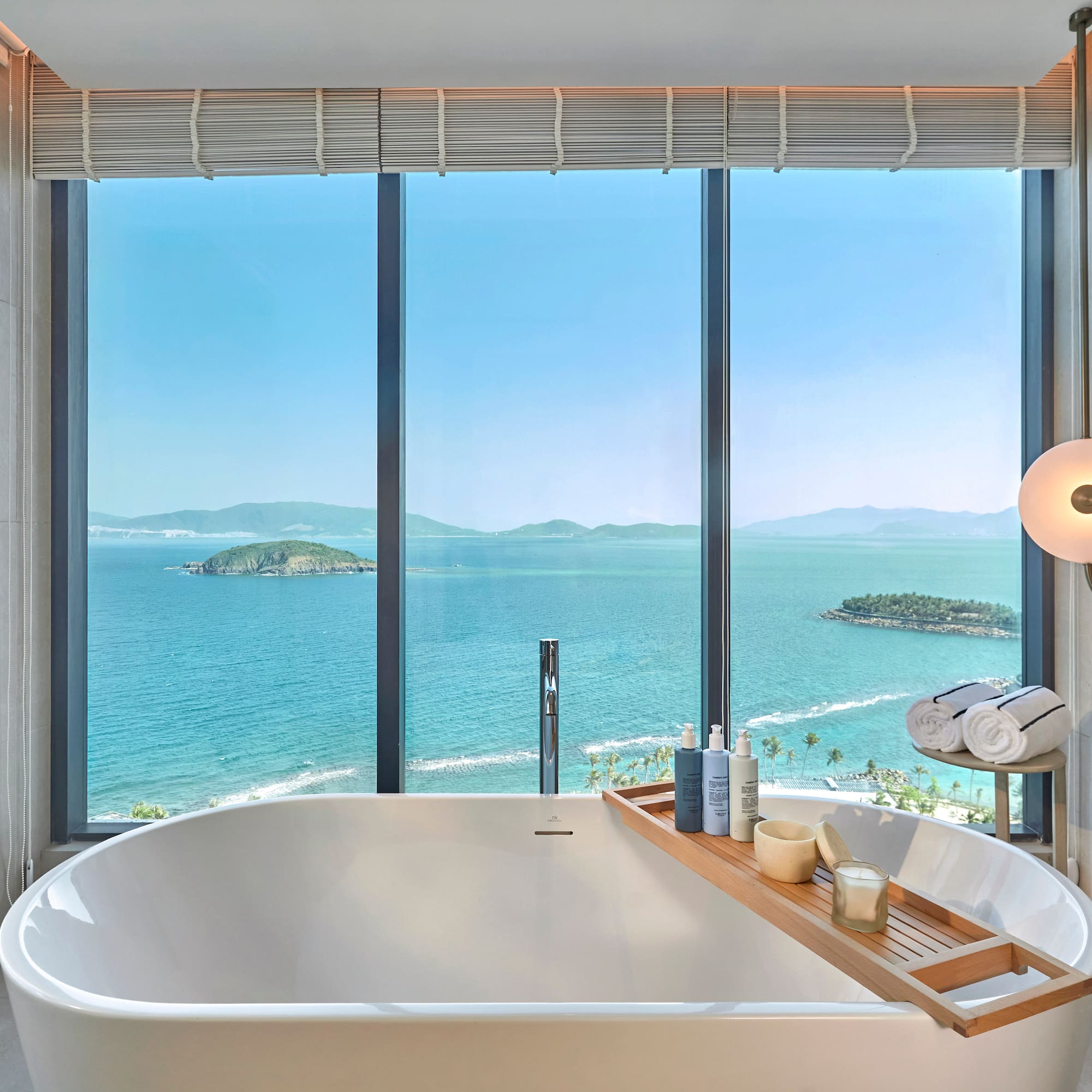 Luxury bathroom with ocean view, freestanding tub, and coastal islands.
