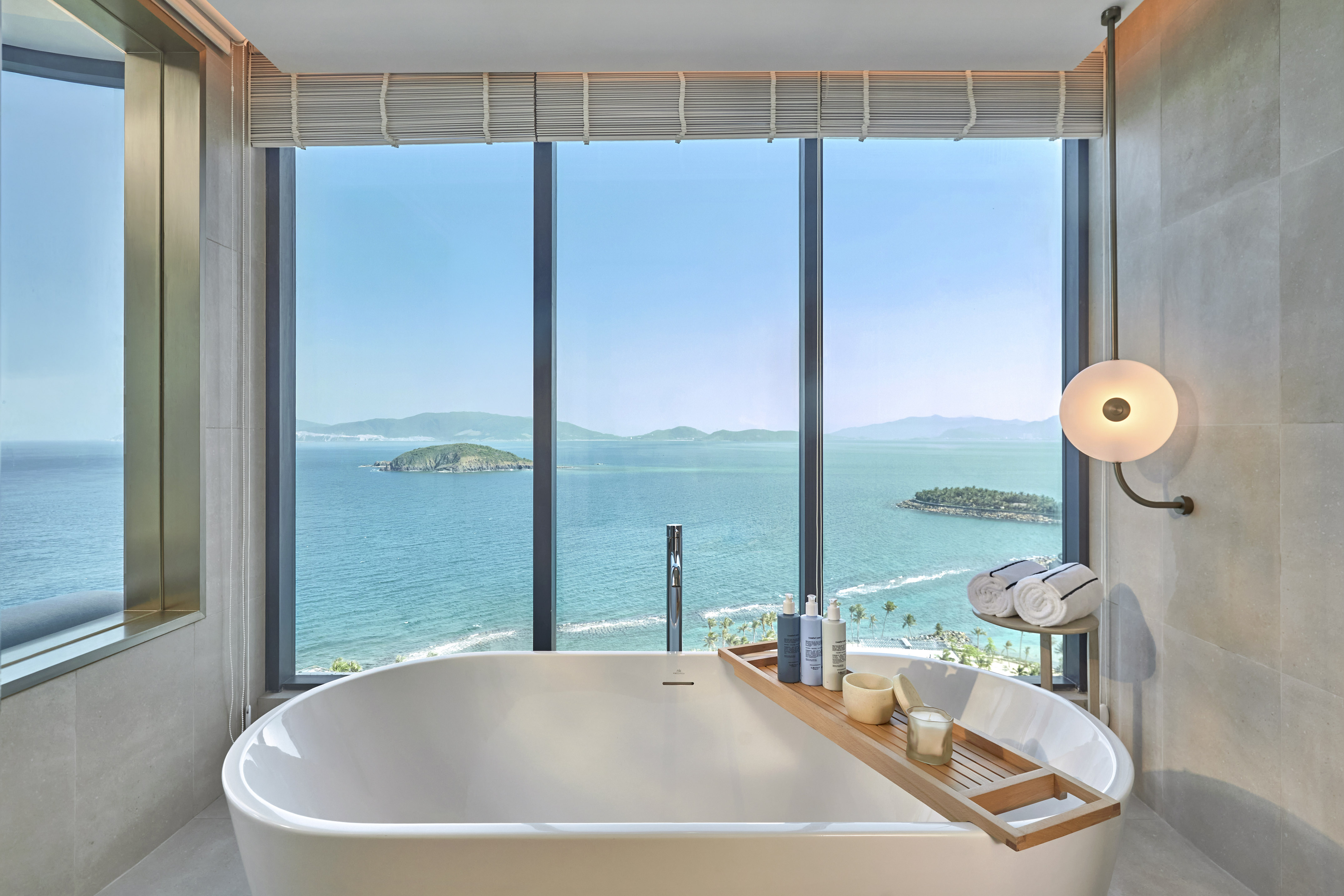 Luxury bathroom with ocean view, freestanding tub, and coastal islands.