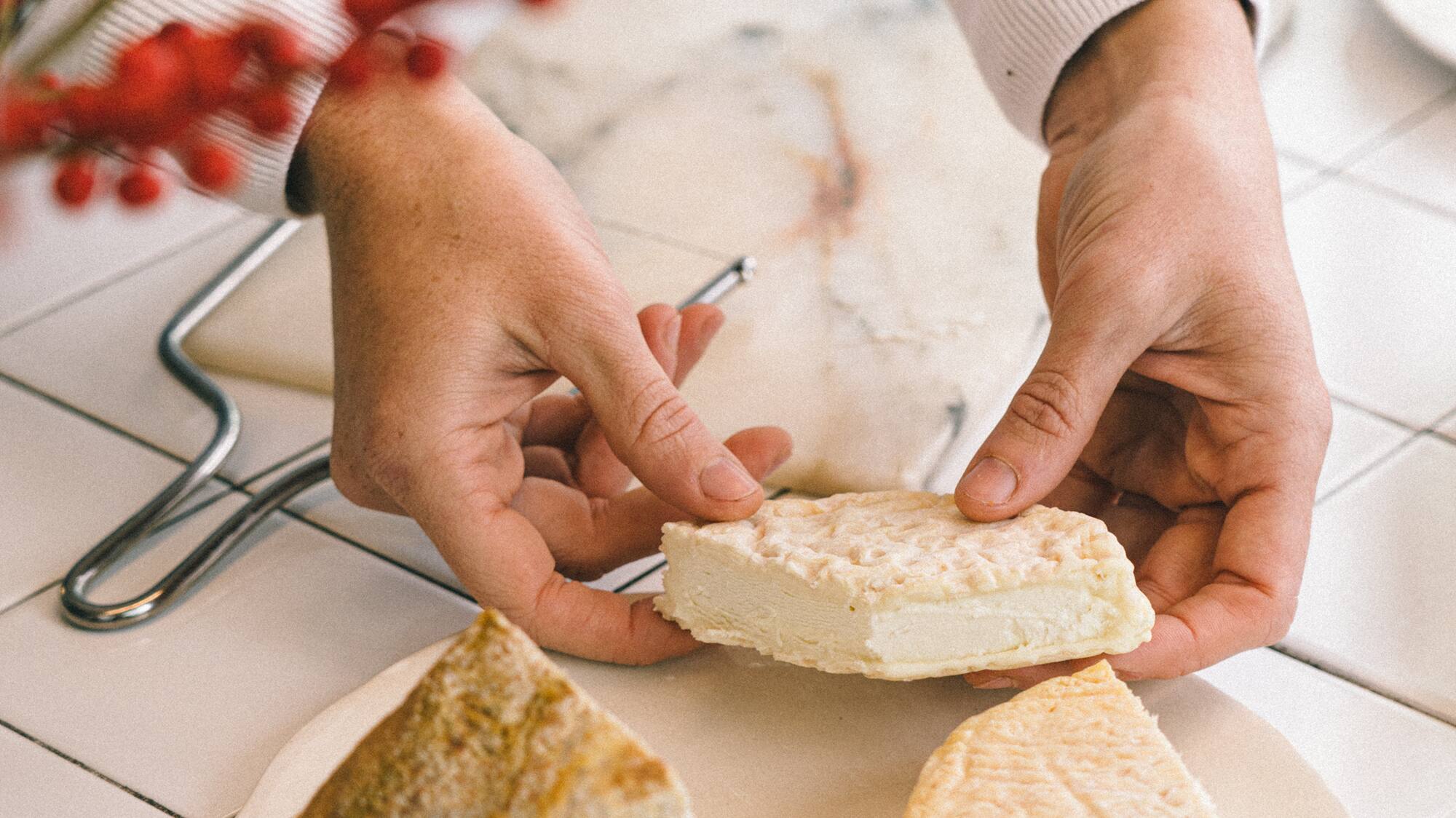 a person holding a piece of cheese