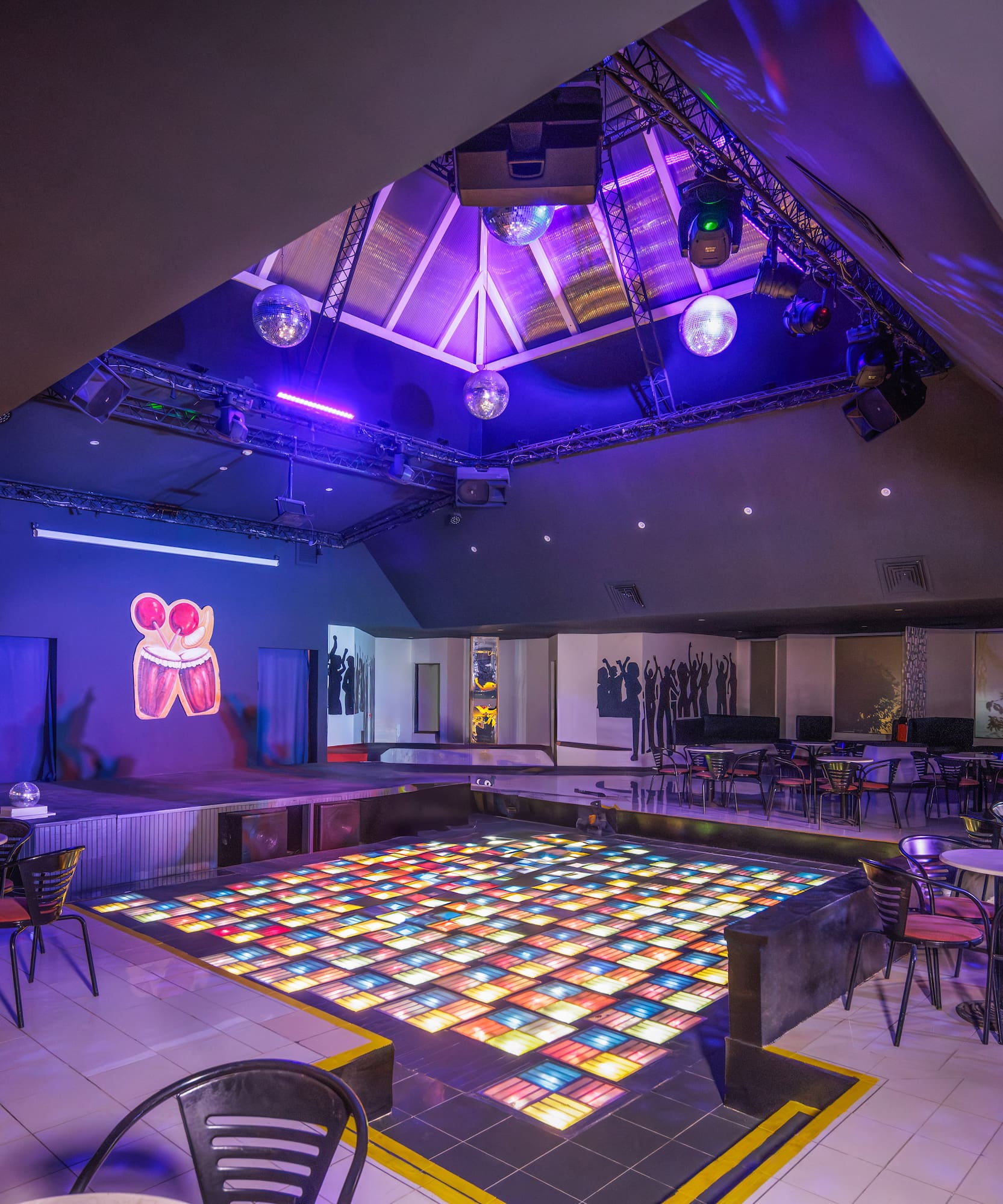 a room with tables and chairs and a dance floor