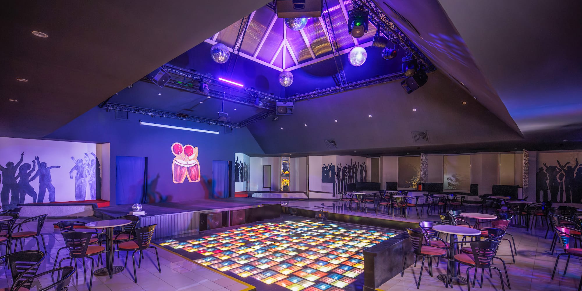 a room with tables and chairs and a dance floor