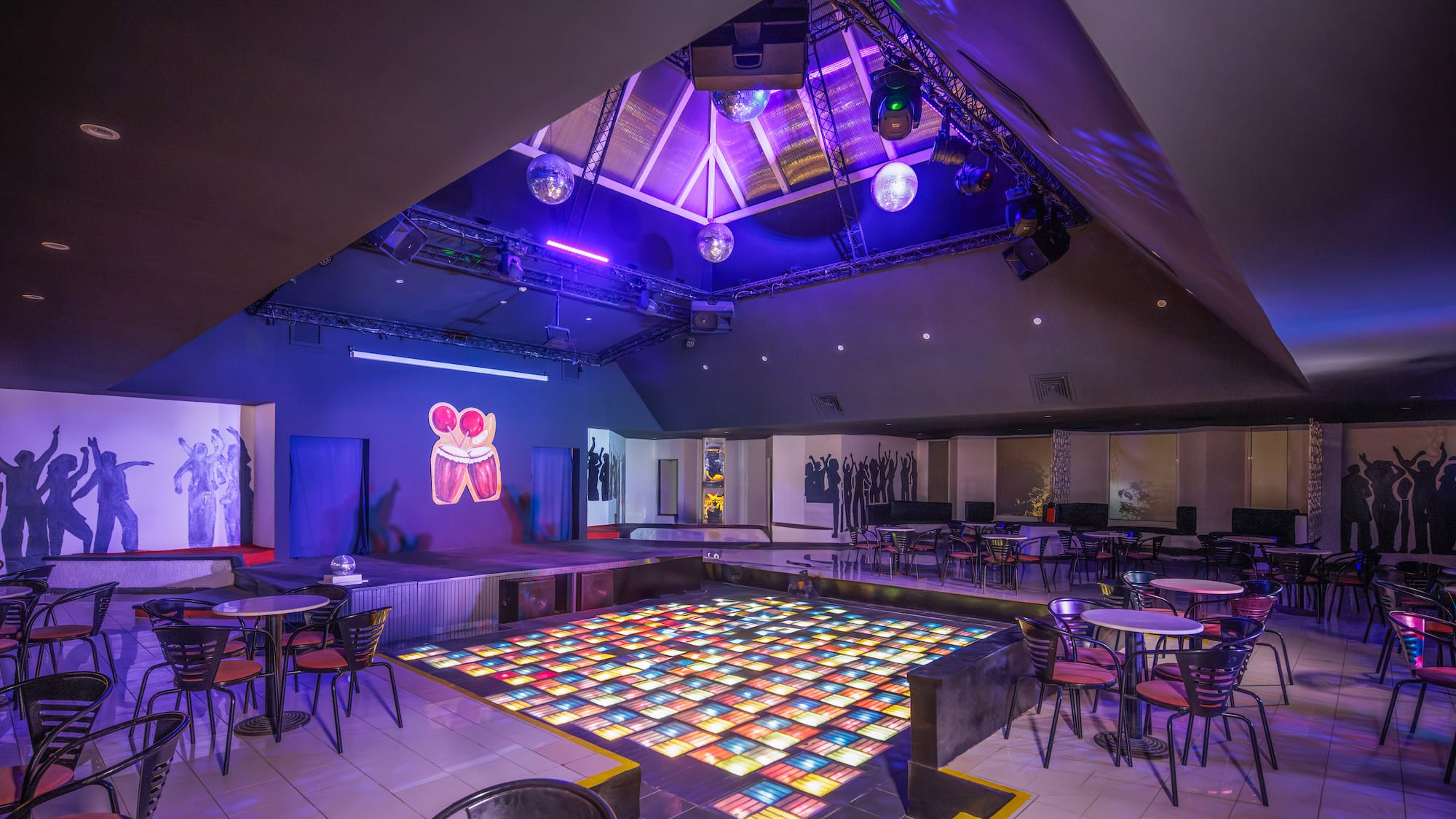 a room with tables and chairs and a dance floor