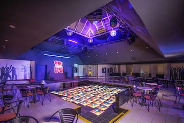 a room with tables and chairs and a dance floor
