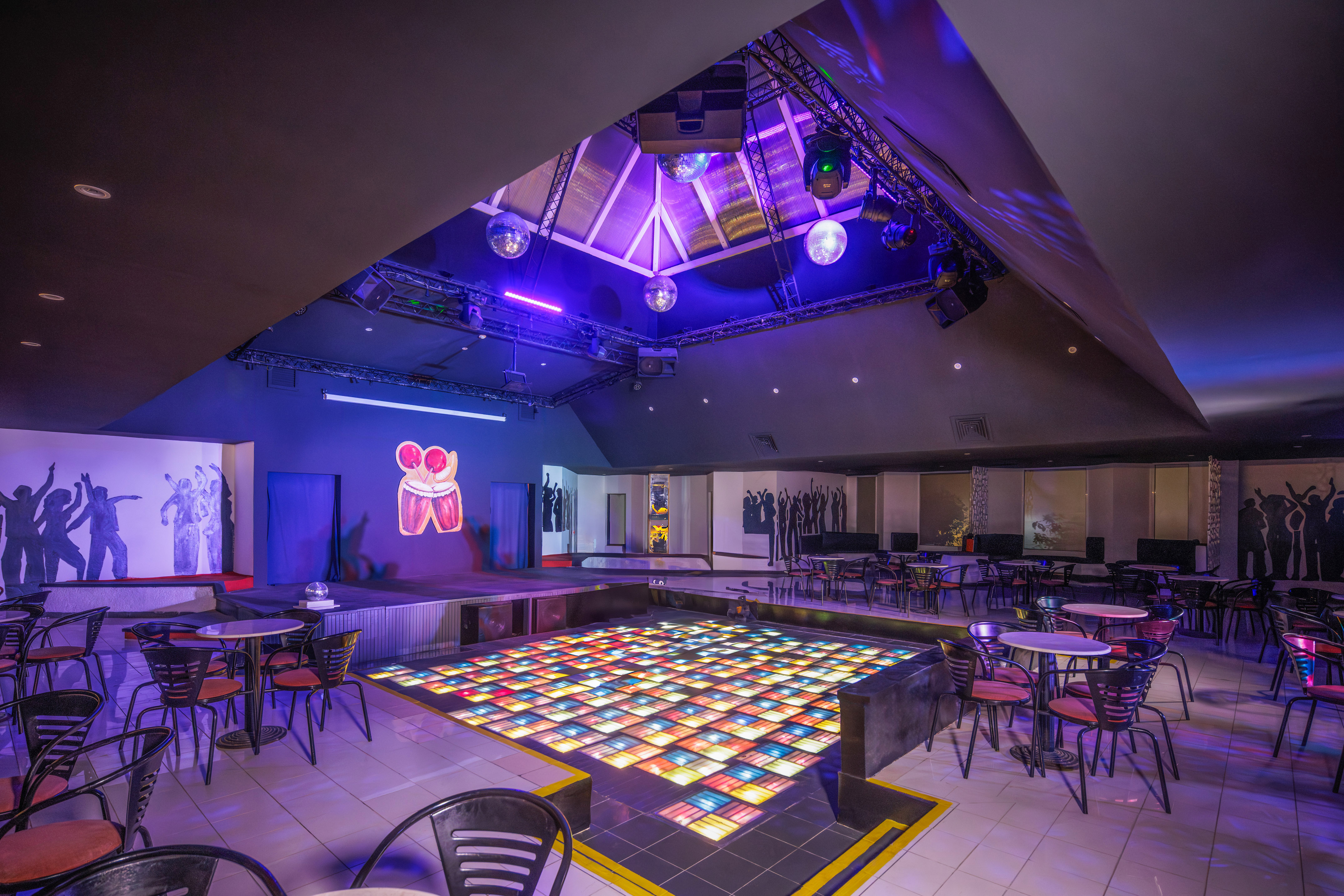 a room with tables and chairs and a dance floor