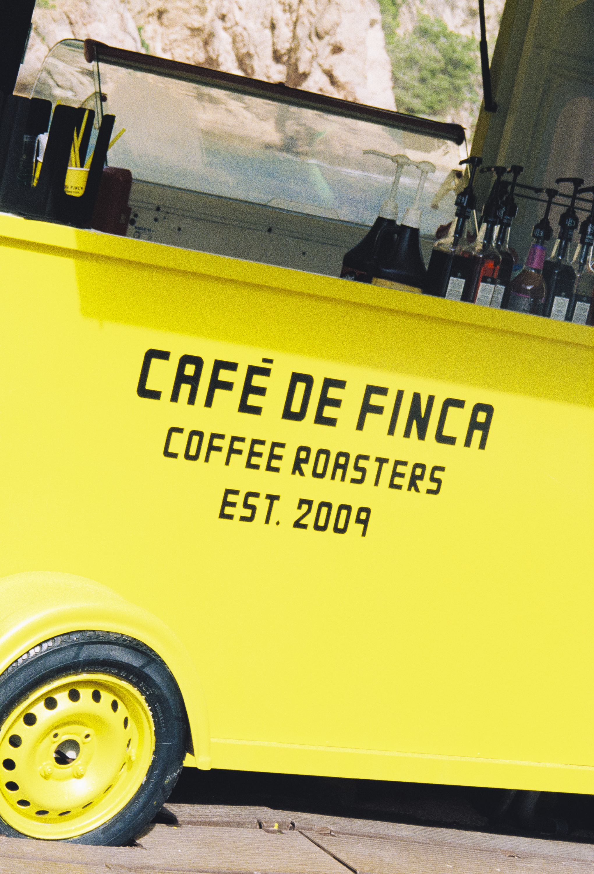 Yellow 'Café de Finca Coffee Roasters' mobile coffee cart.