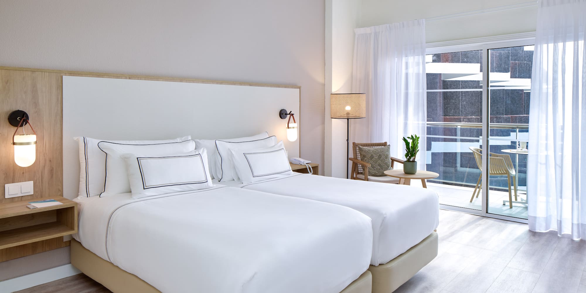 a bedroom with two beds and a glass door