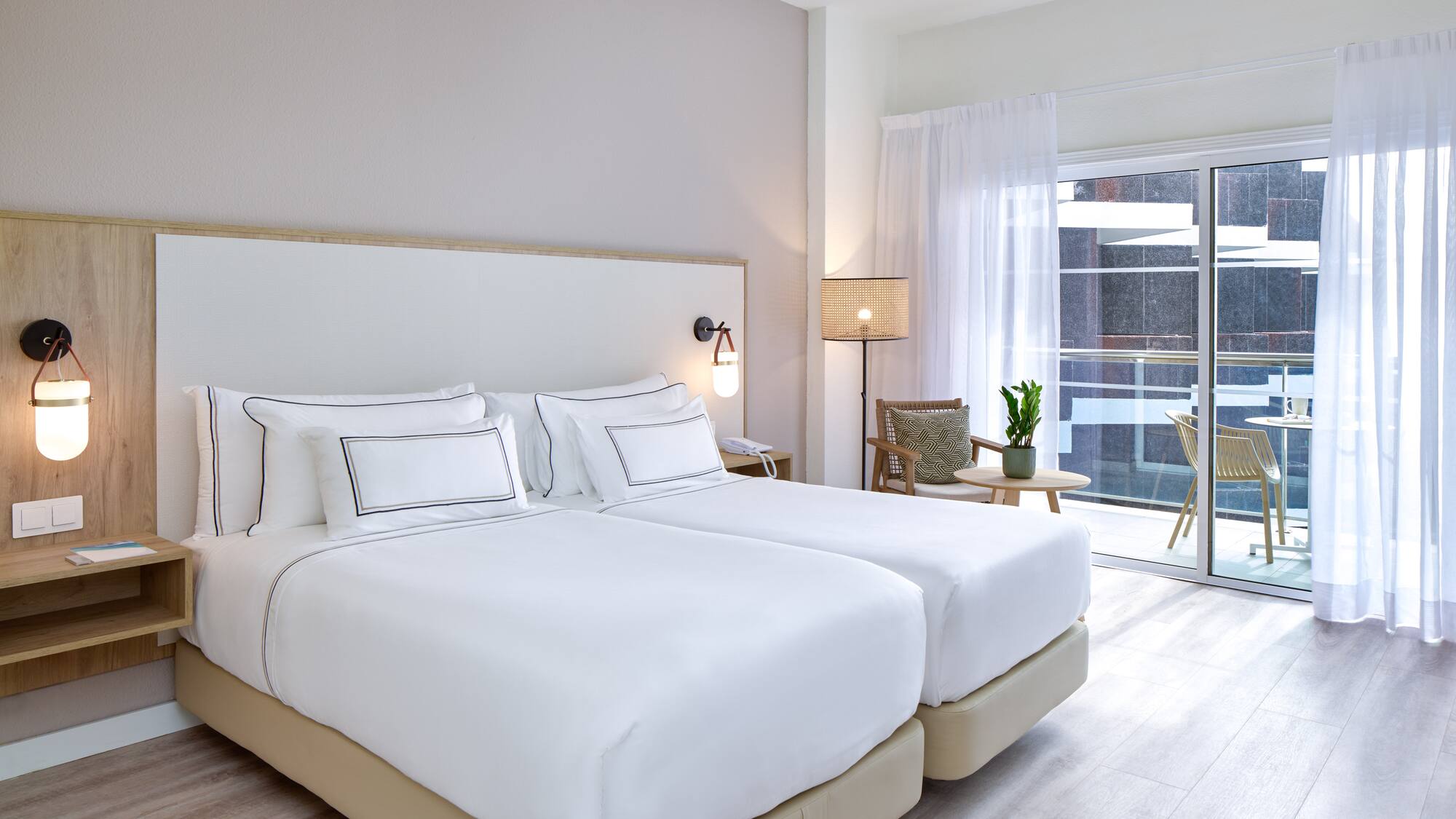 a bedroom with two beds and a glass door