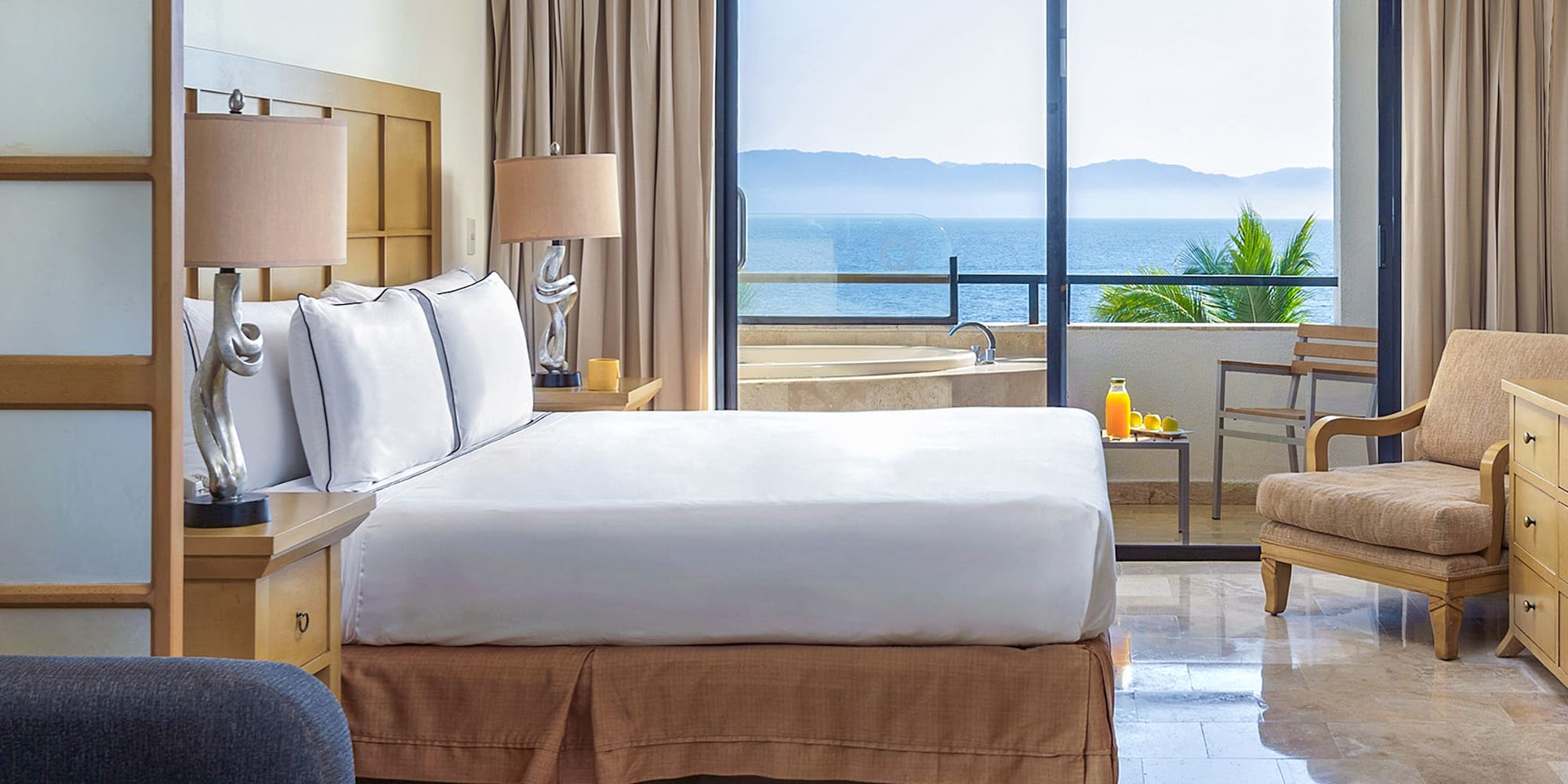 a bedroom with a large window overlooking the ocean