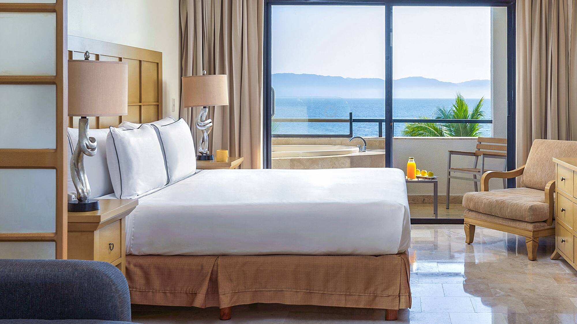 a bedroom with a large window overlooking the ocean