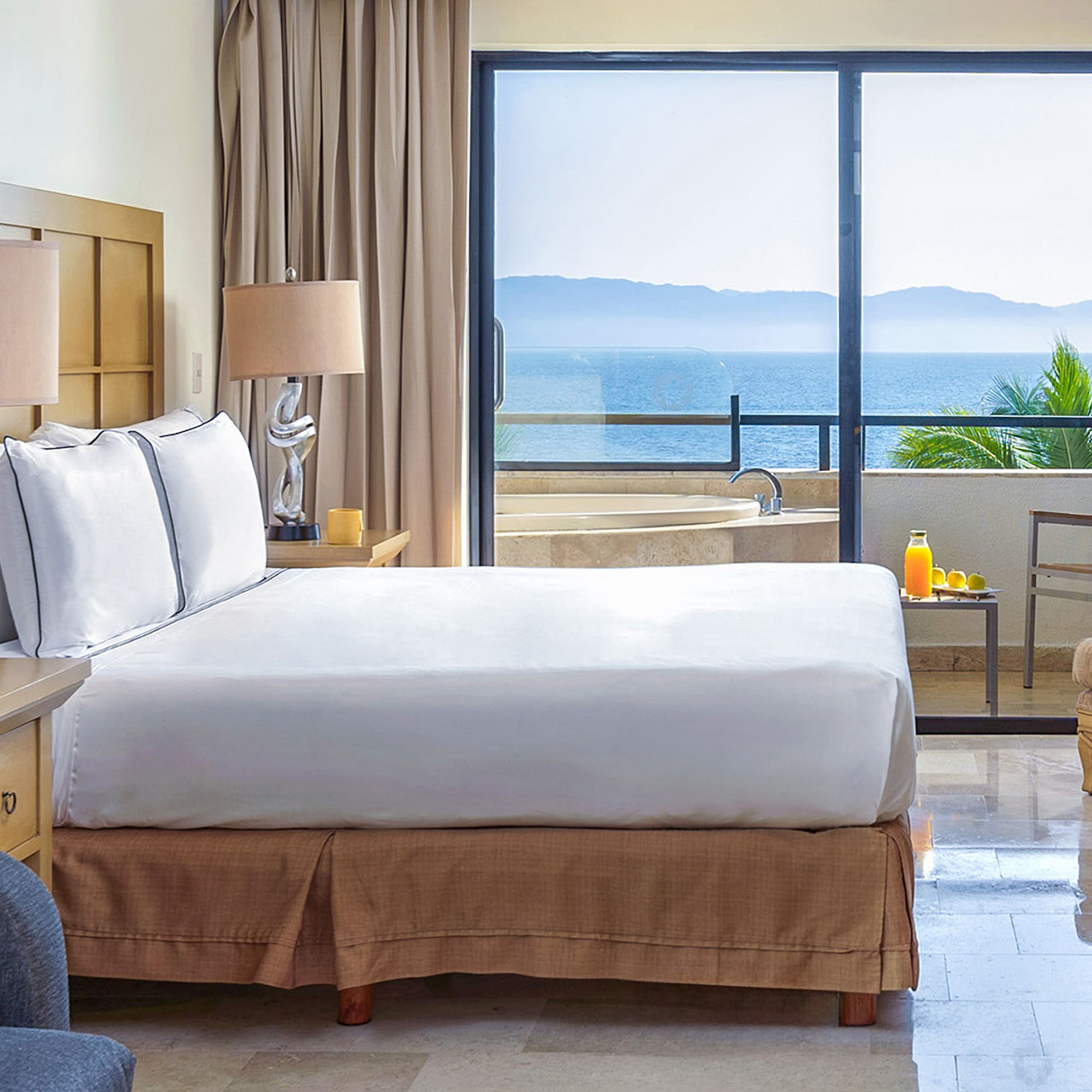 a bedroom with a large window overlooking the ocean