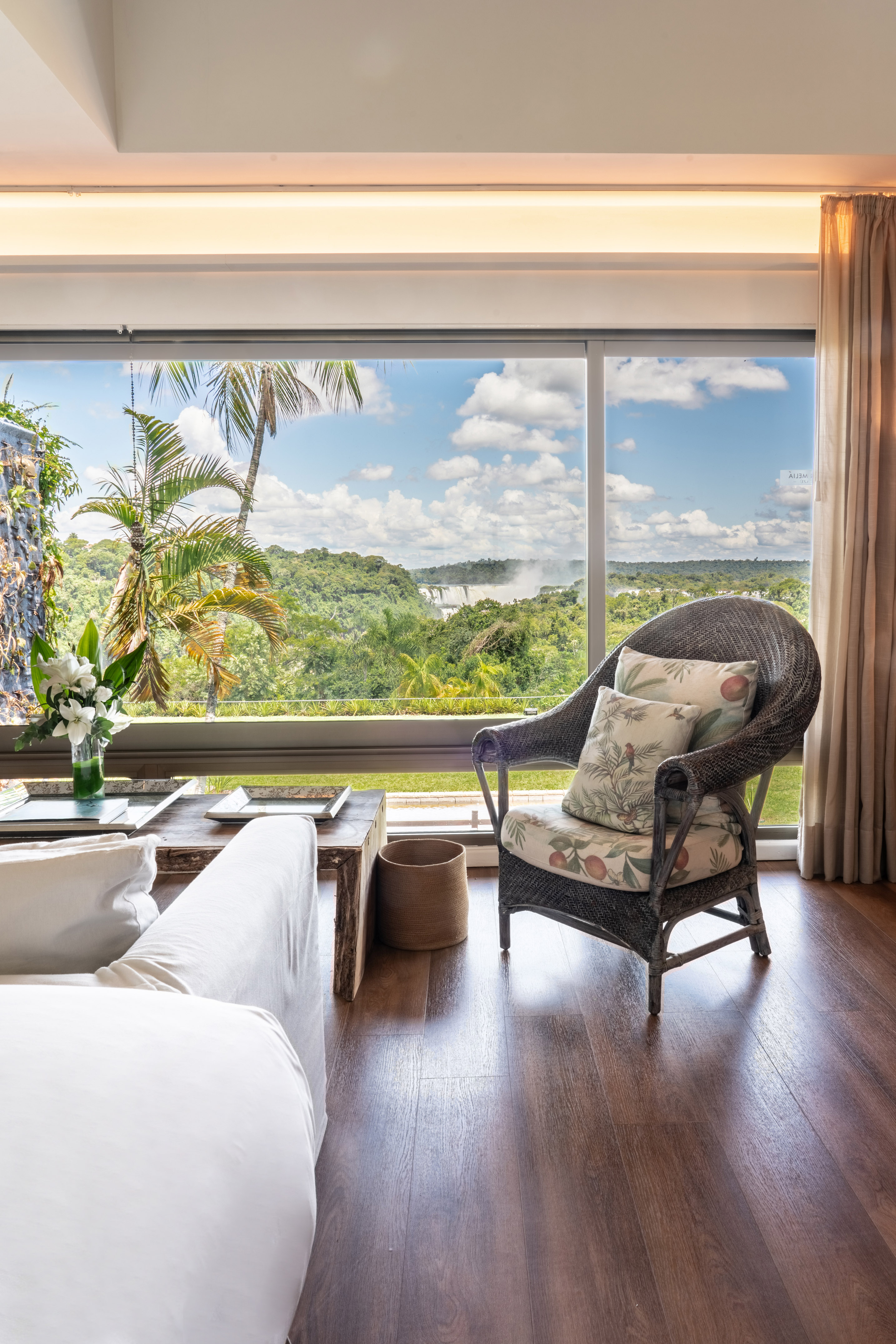 Iguazu Falls jungle view from luxury living room with wicker armchair.