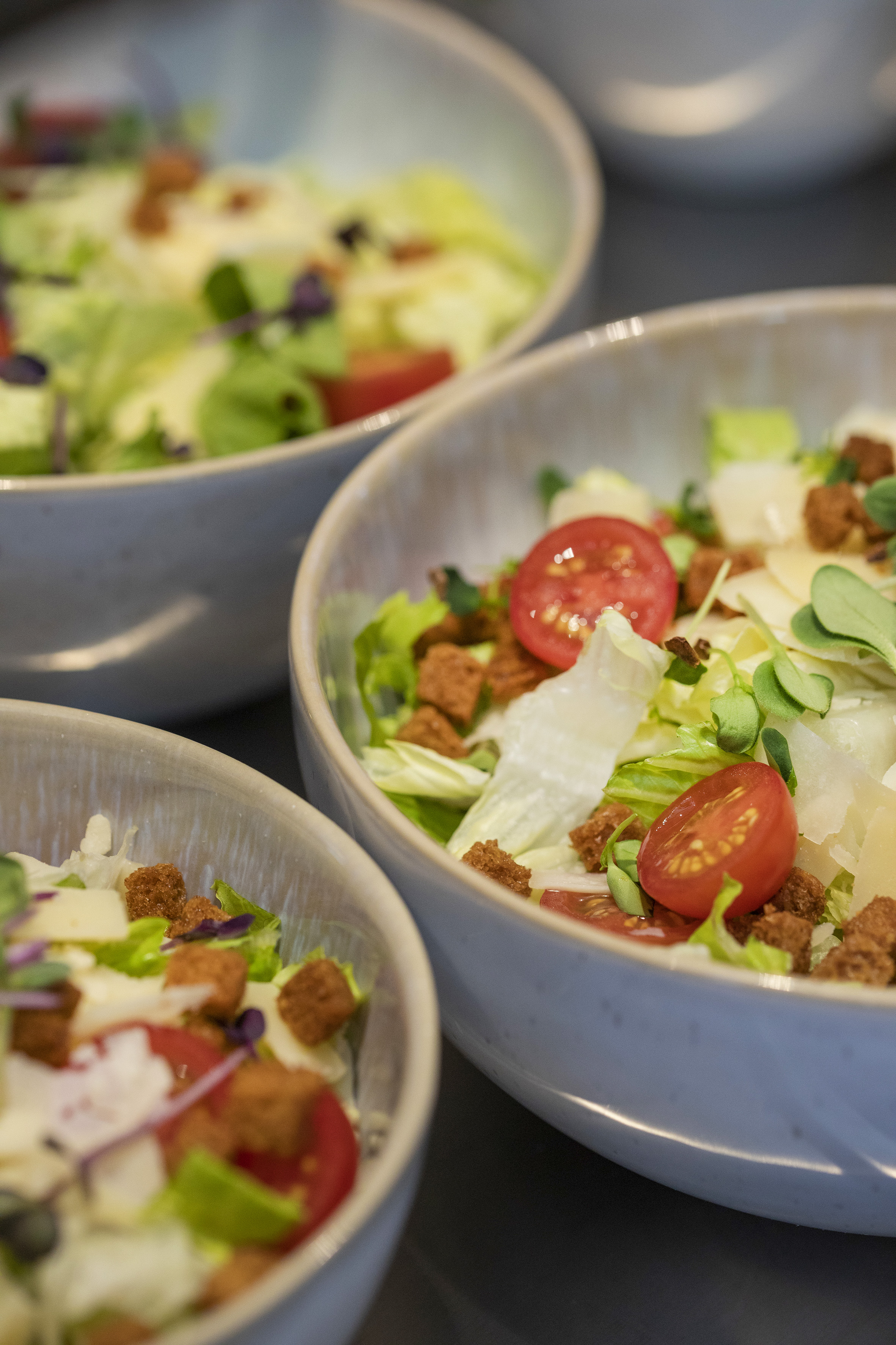 Fresh healthy salads in bowls with lettuce, tomatoes, croutons, and cheese. - De Gaart, Cuisine locale - INNSiDE Luxembourg, Luxembourg