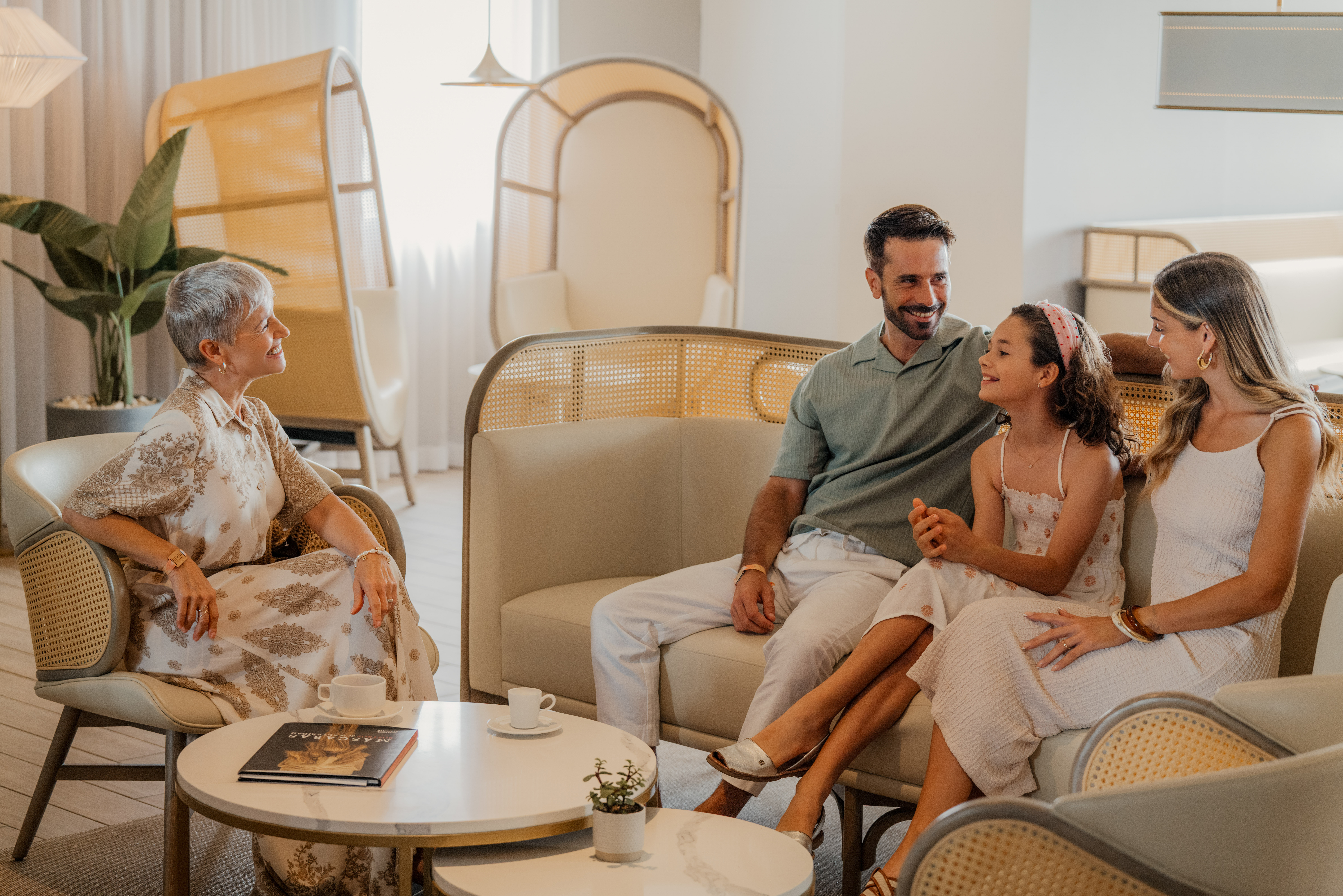 Multi-generational family enjoying a coffee break in a modern hotel lounge.