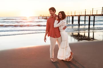 a man and woman hugging on a beach
