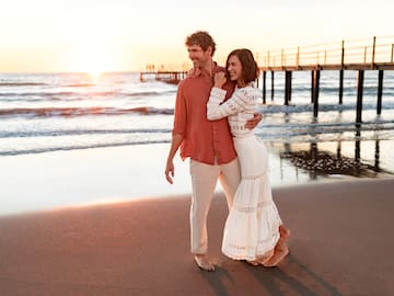 a man and woman hugging on a beach