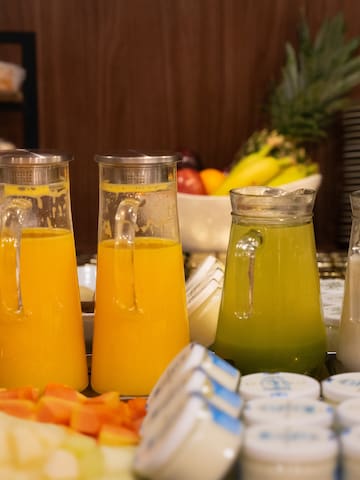 a group of glasses of juice and a variety of fruits