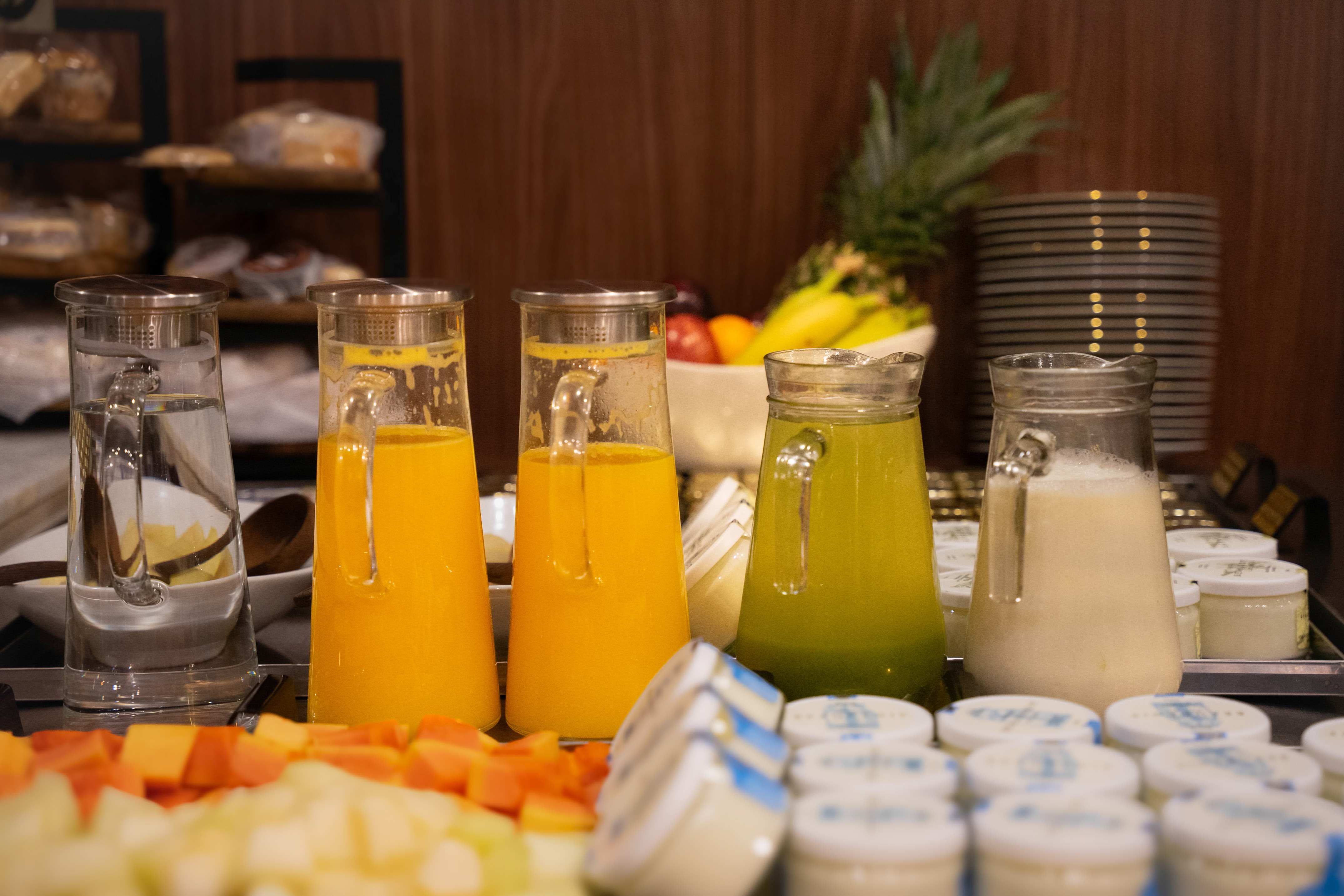 a group of glasses of juice and a variety of fruits