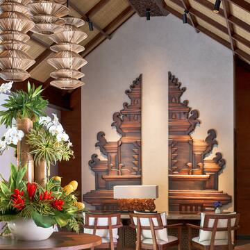 a room with a table and chairs and a vase of flowers