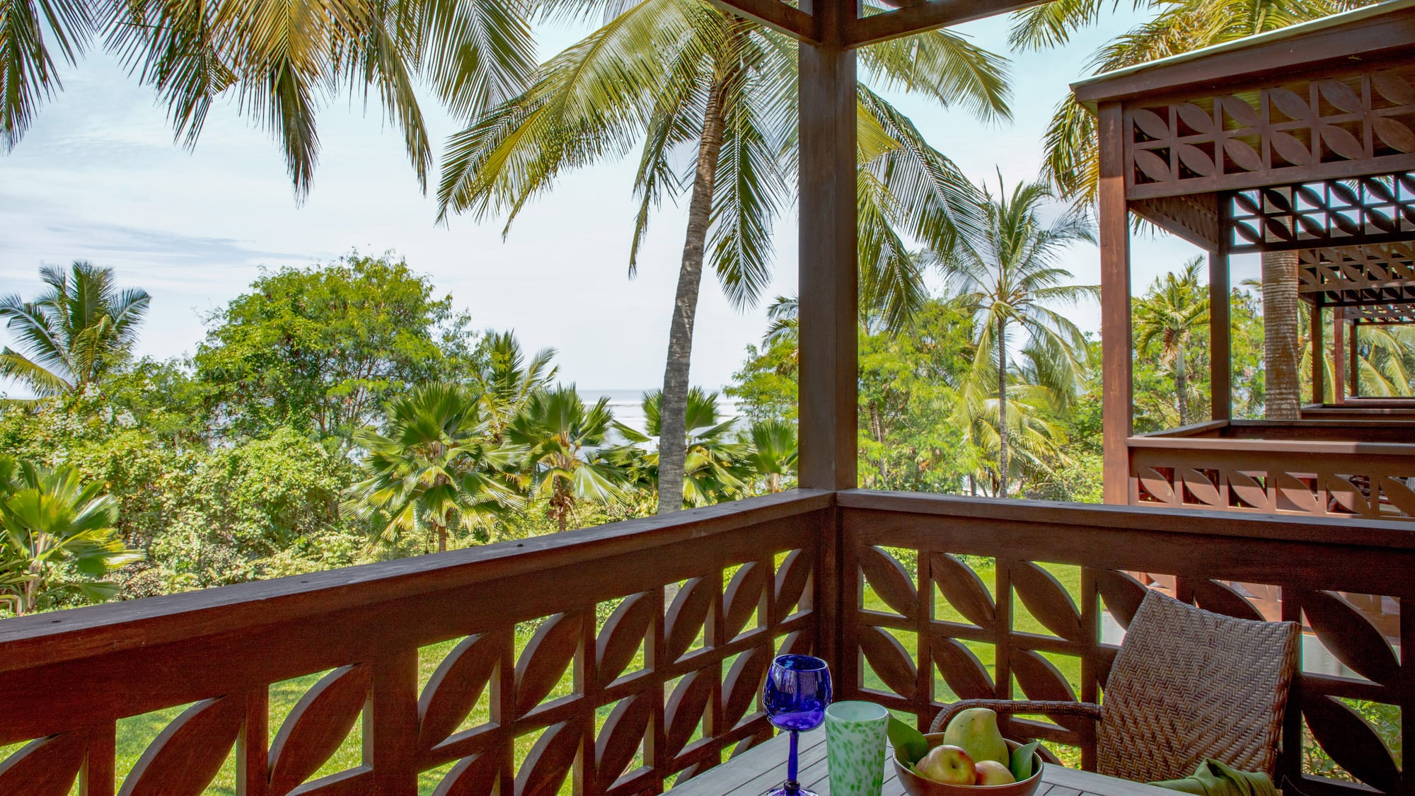 a wooden table with fruit on it and a blue glass on it