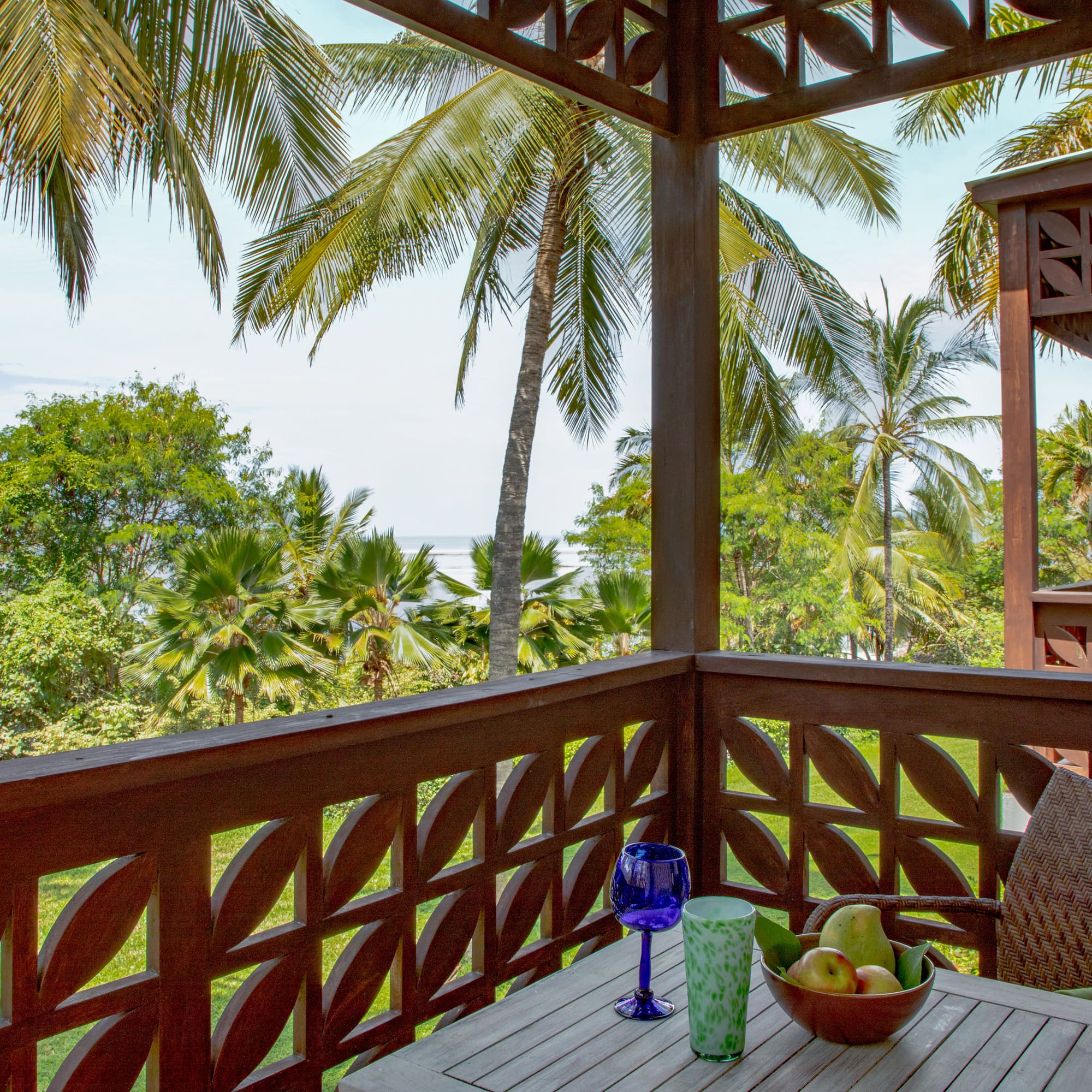 a wooden table with fruit on it and a blue glass on it