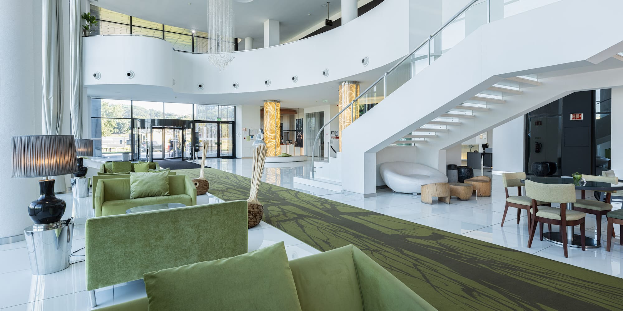 a large white room with green couches and stairs