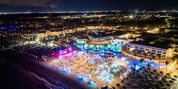 aerial view of a beach with a large pool and buildings at night