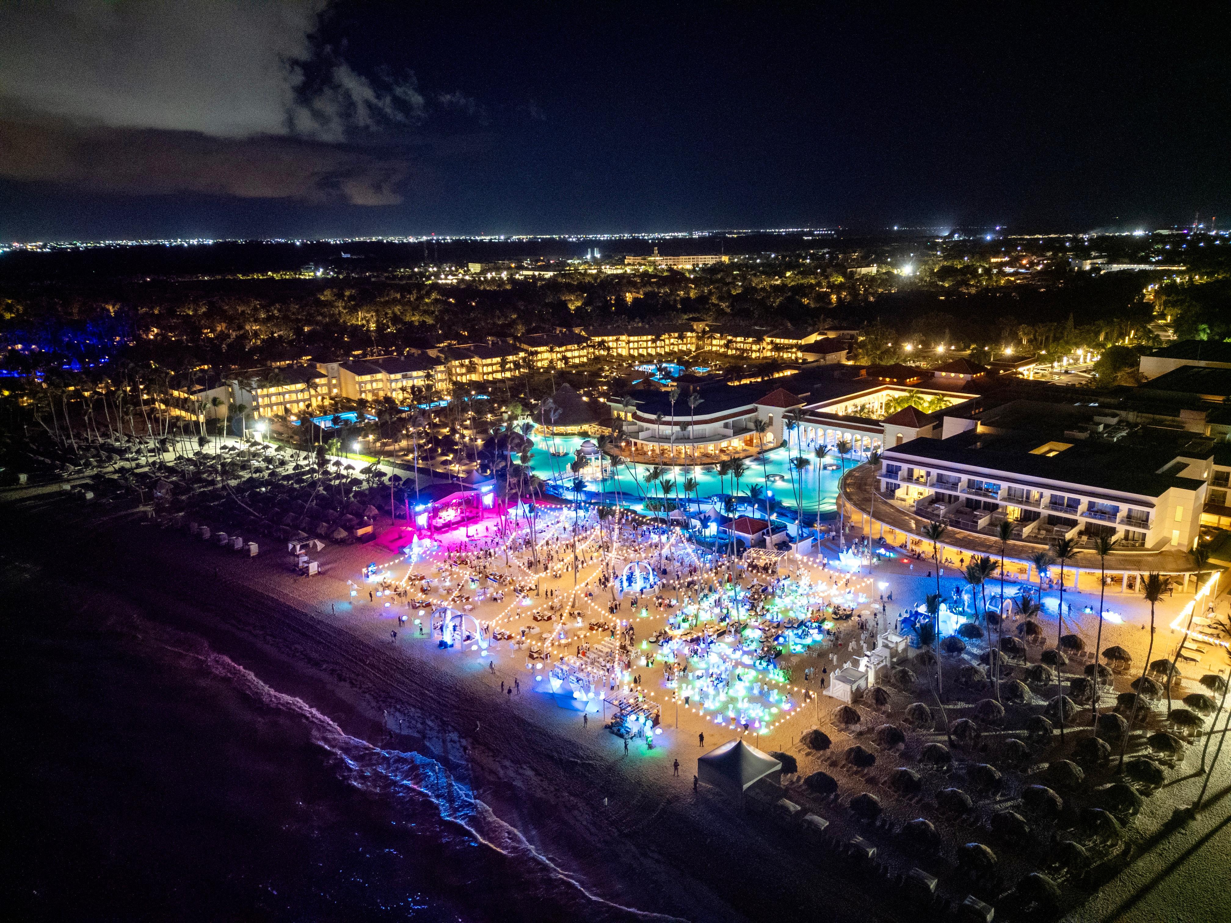aerial view of a beach with a large pool and buildings at night