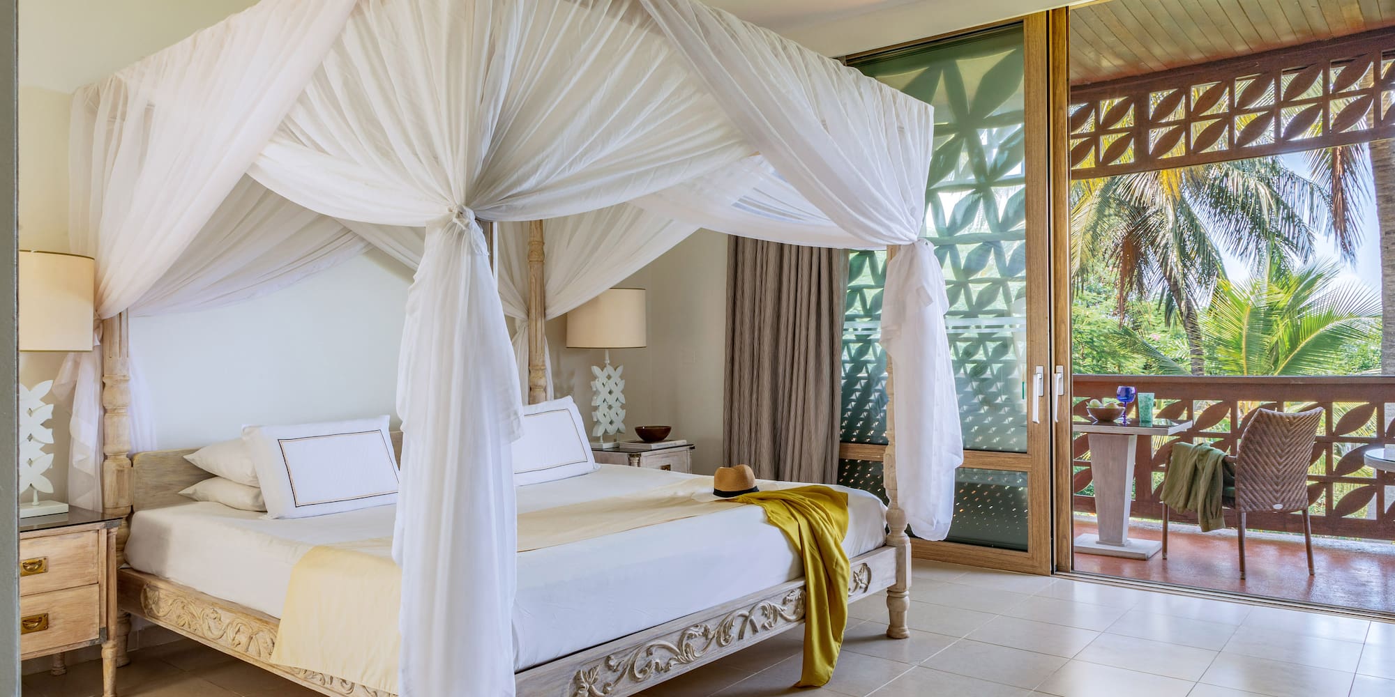 a white canopy bed in a room with a balcony