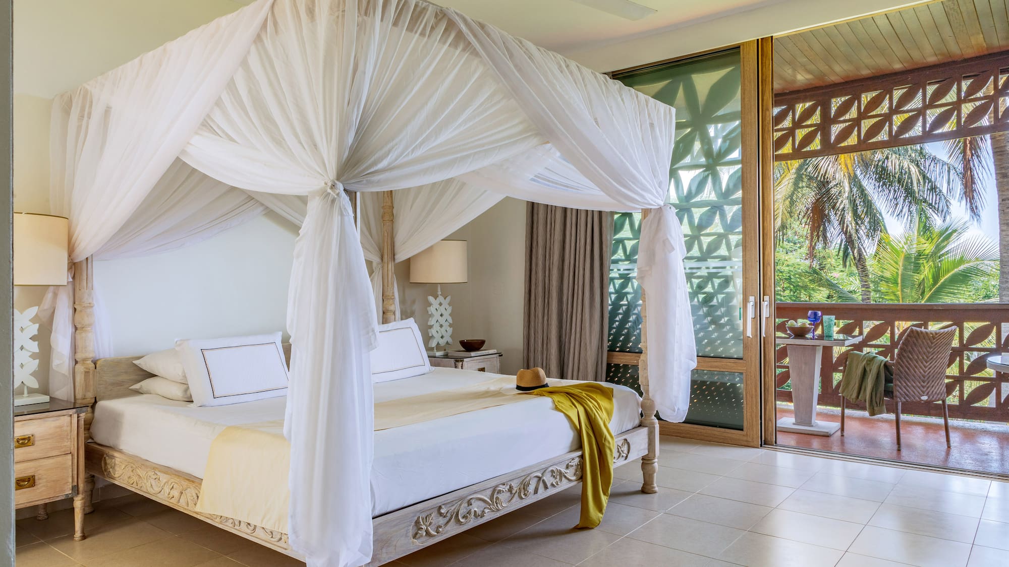 a white canopy bed in a room with a balcony