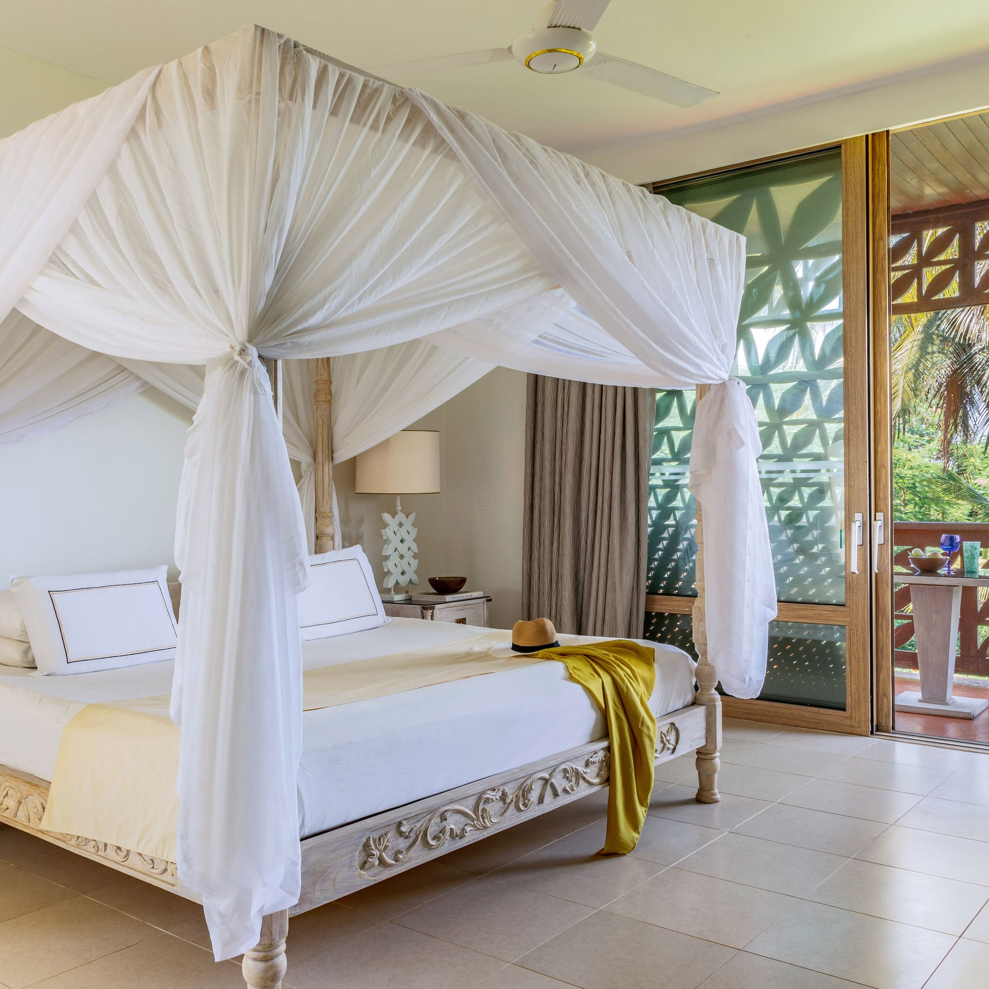 a white canopy bed in a room with a balcony