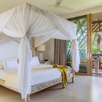 a white canopy bed in a room with a balcony