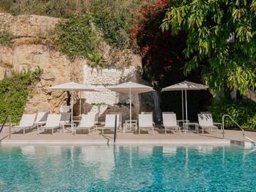 a pool with chairs and umbrellas