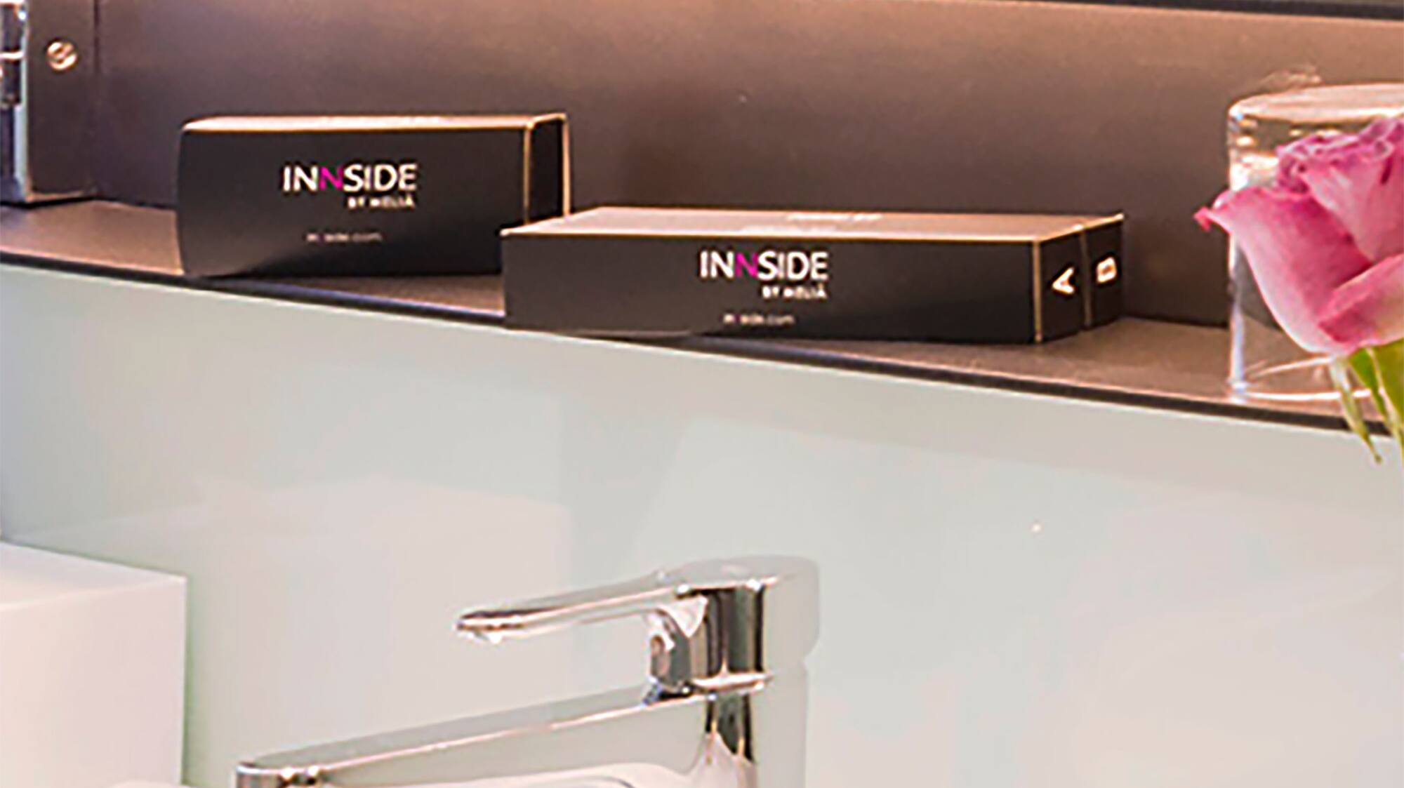 a bathroom sink with a mirror and a pink rose