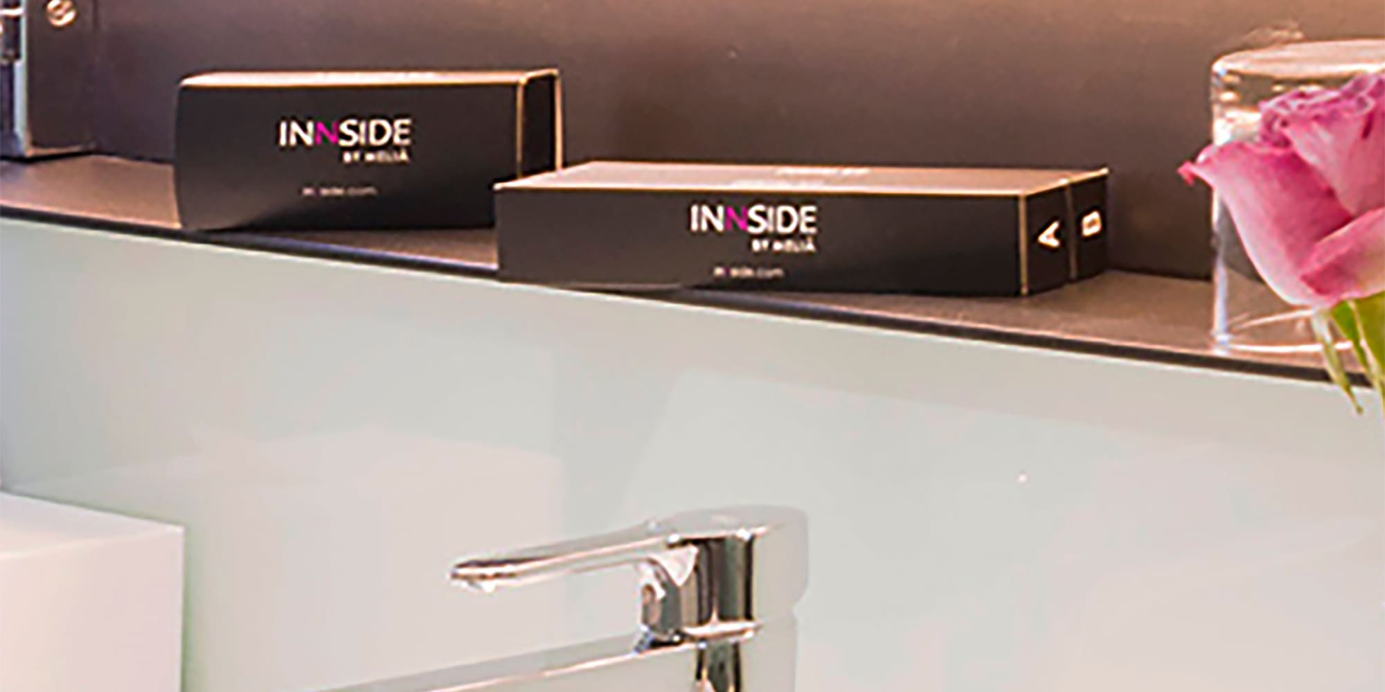 a bathroom sink with a mirror and a pink rose