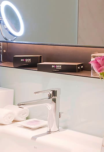 a bathroom sink with a mirror and a pink rose