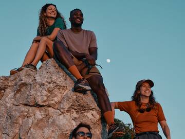 a group of people sitting on a rock