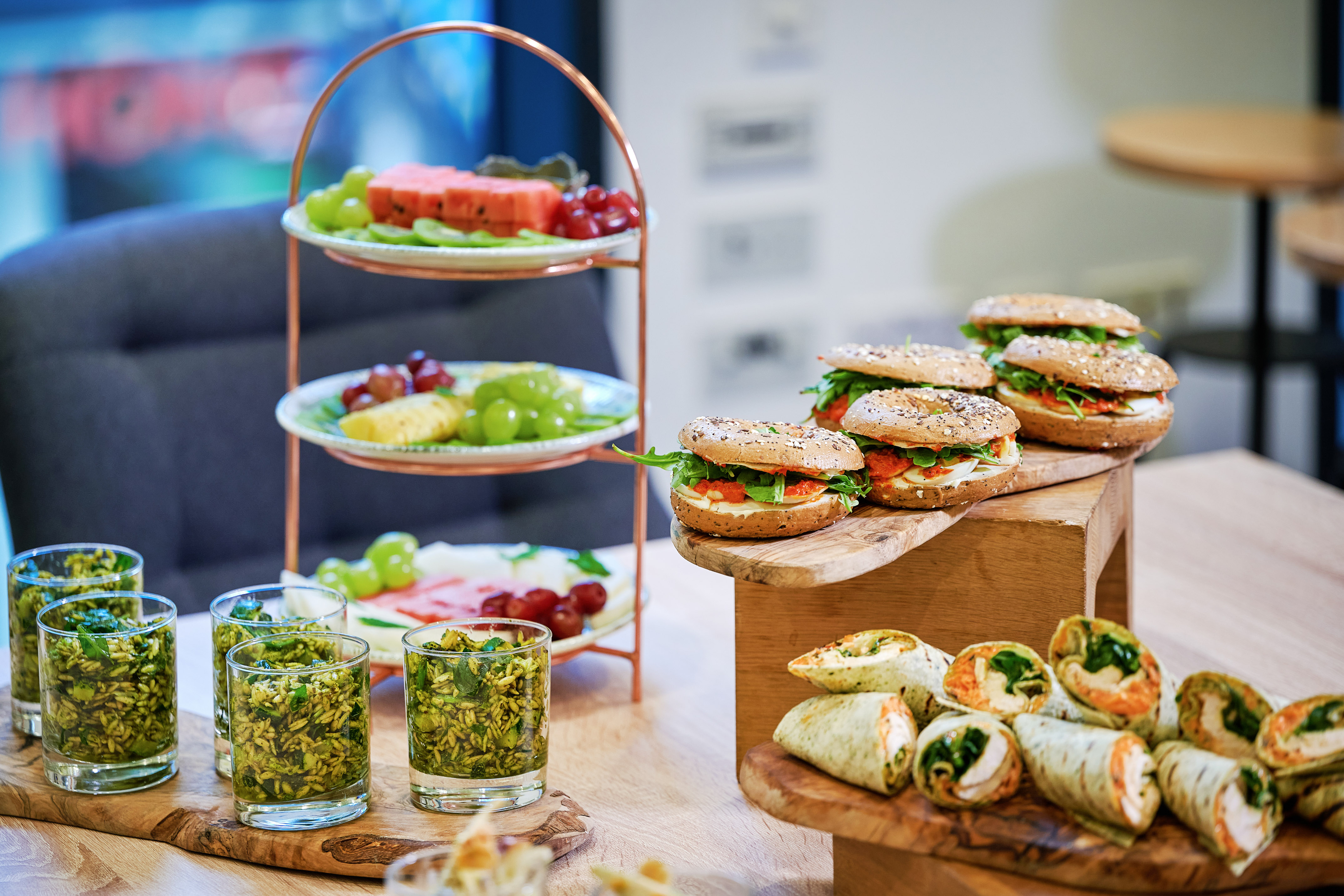 Event catering: tiered fruit stand, fresh bagels, wraps, and green rice salad.
