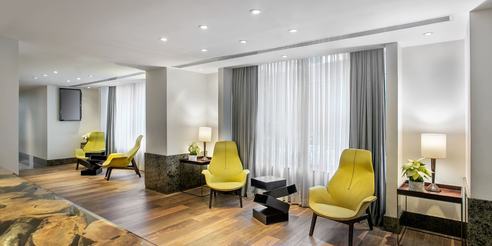 a room with yellow chairs and a glass table