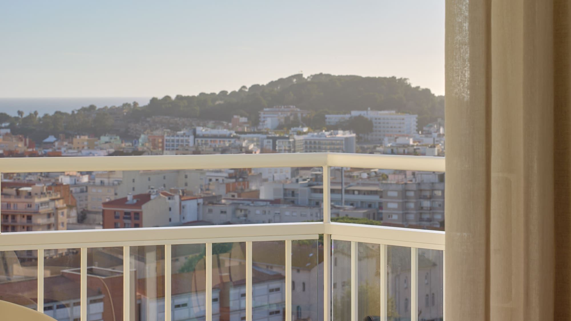 a balcony with a view of a city and a beach